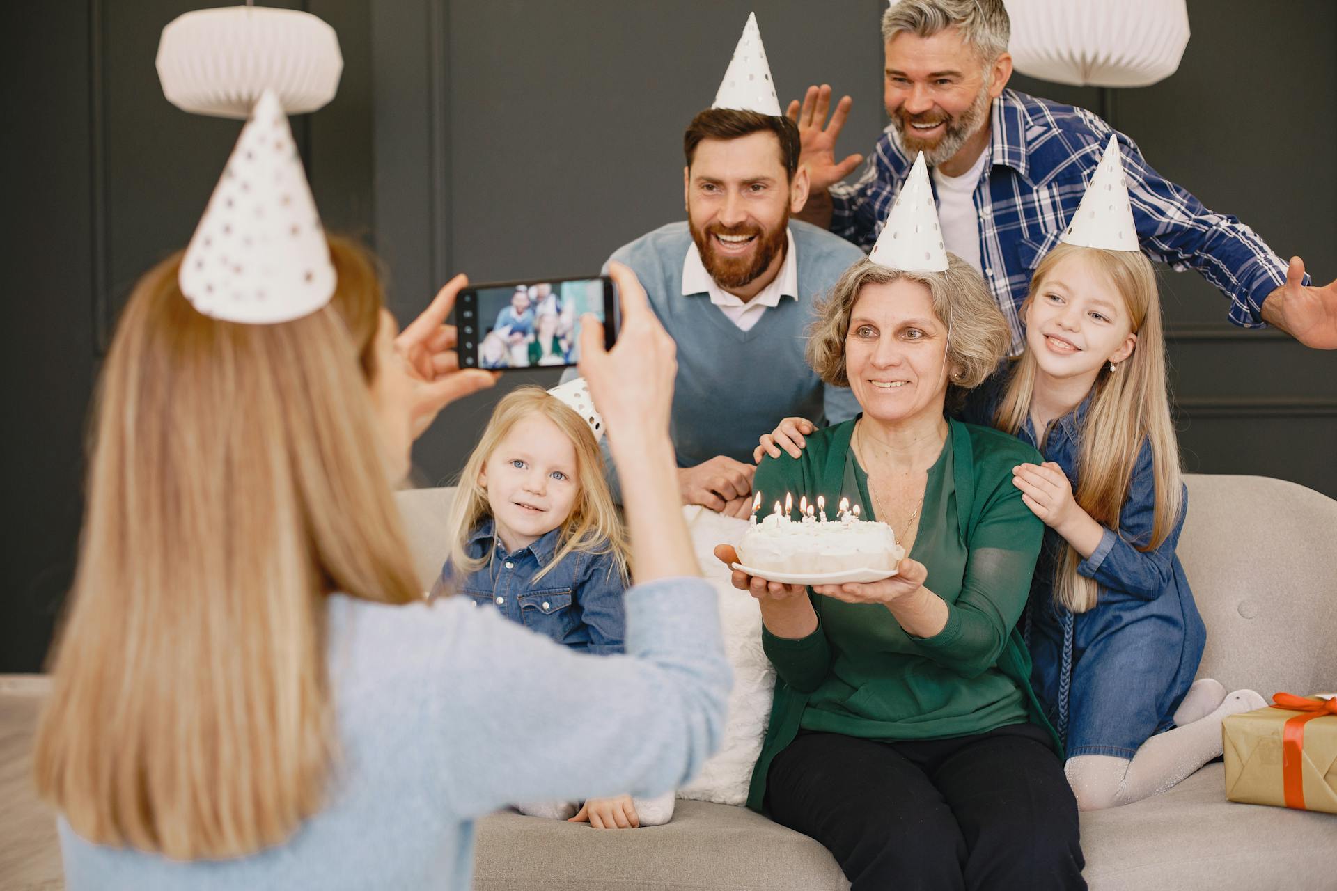 Une femme cliquant sur la photo de sa famille lors d'une célébration d'anniversaire | Source : Pexels