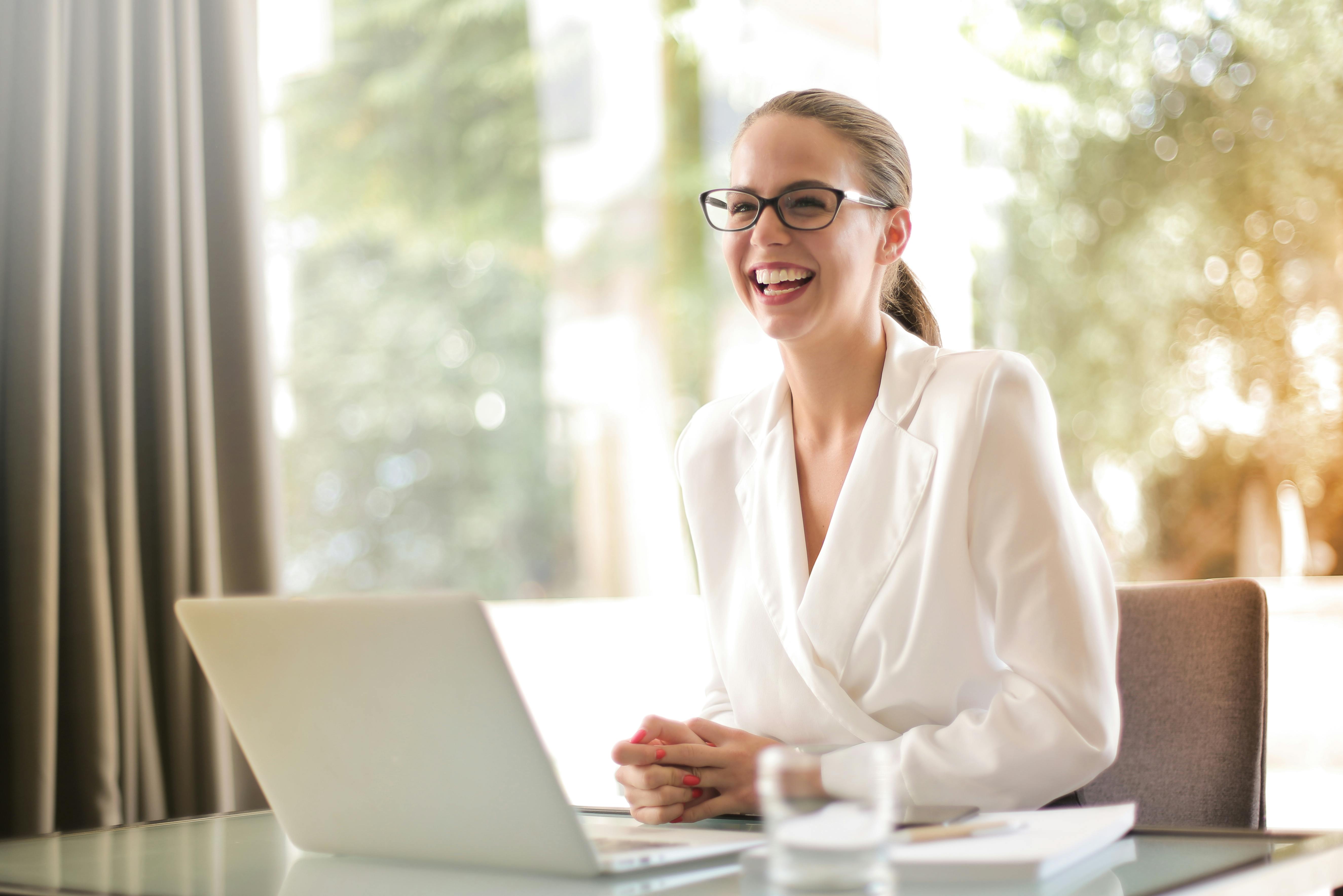 Une femme heureuse dans son bureau | Source : Pexels