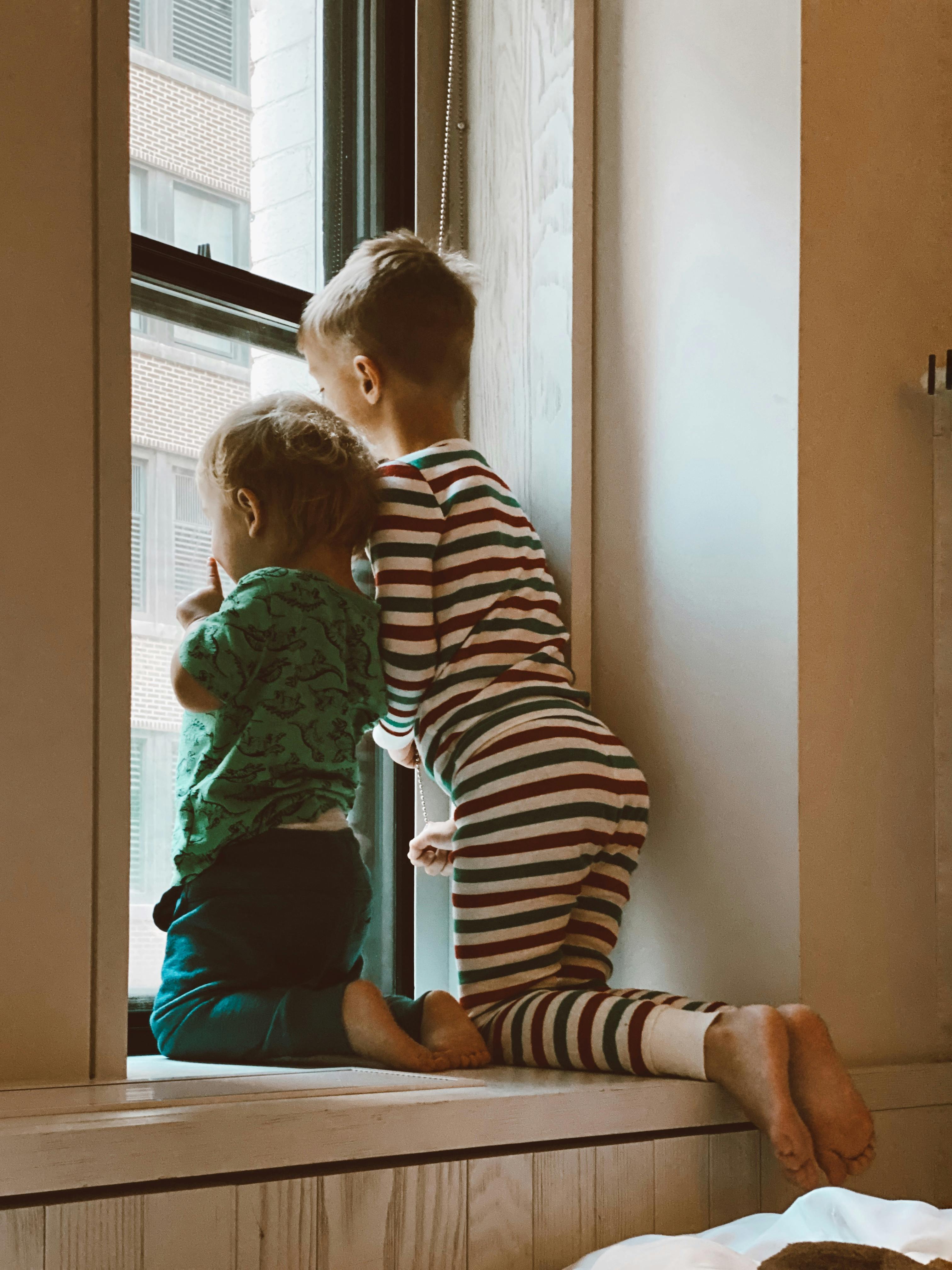Deux enfants qui regardent par la fenêtre | Source : Pexels