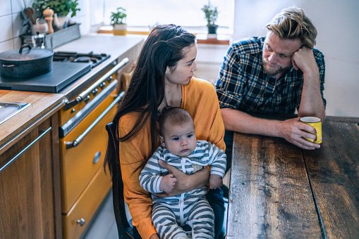 Une famille assis à la table de la cuisine à la maison. | Photo : Getty Images