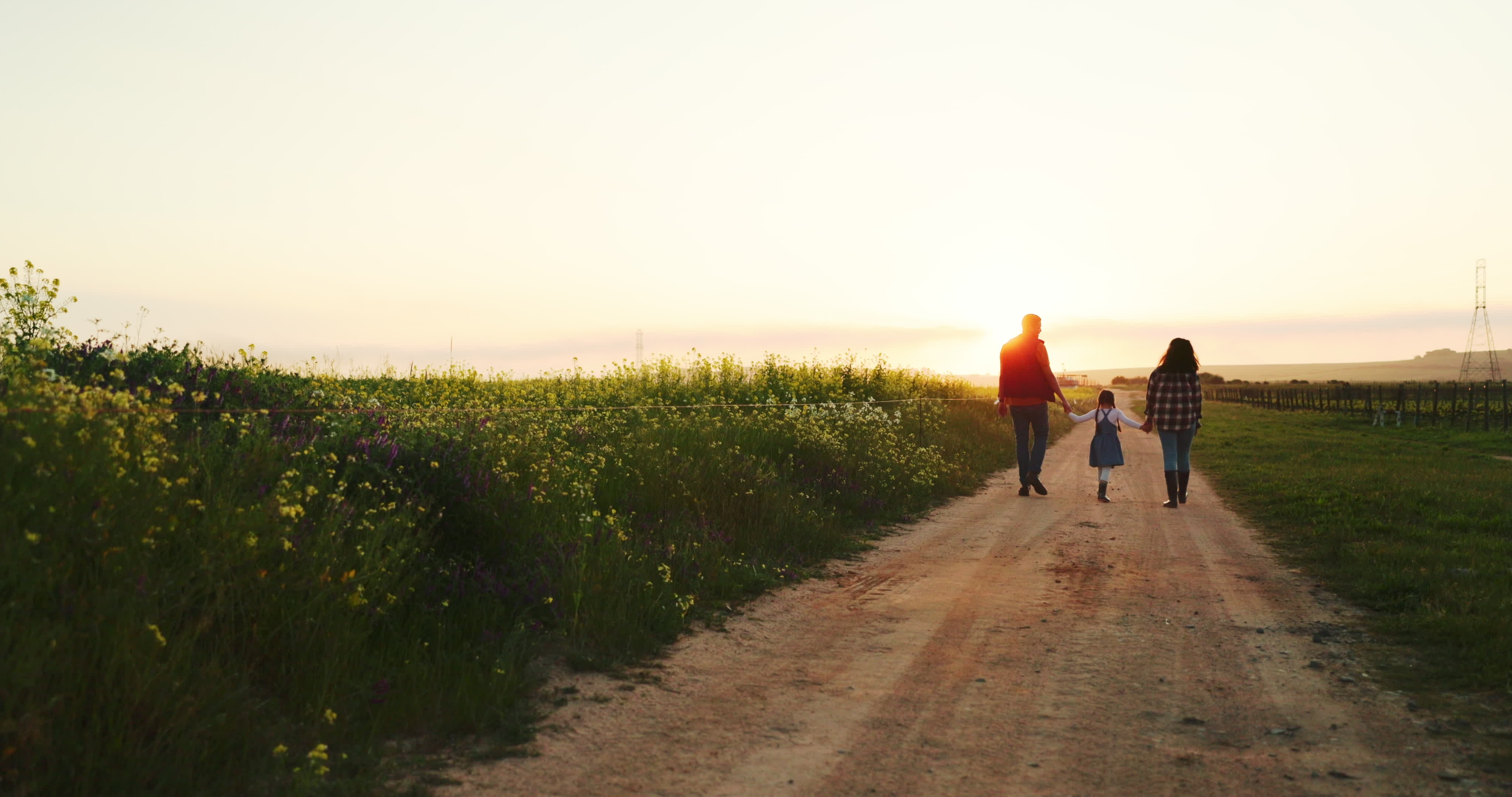 Une famille de trois personnes profitant d'une promenade dans leur ferme | Source : Shutterstock