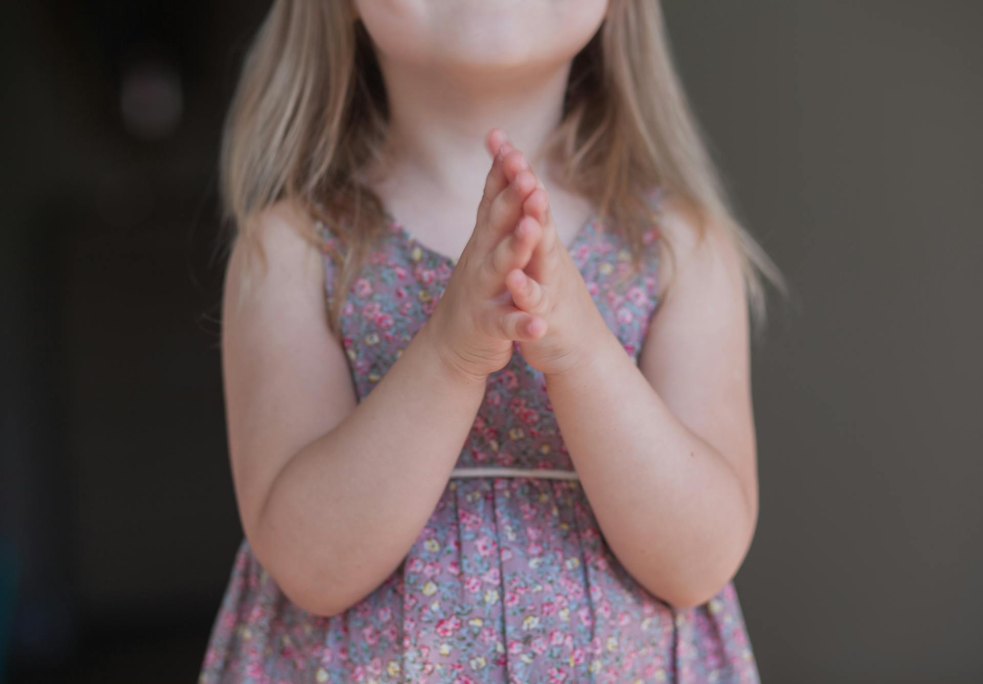 Une petite fille debout, les mains jointes | Source : Pexels