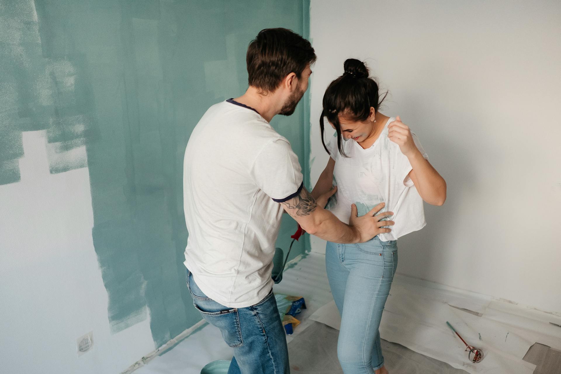 Un couple s'amusant à faire des travaux d'amélioration de la maison | Source : Pexels