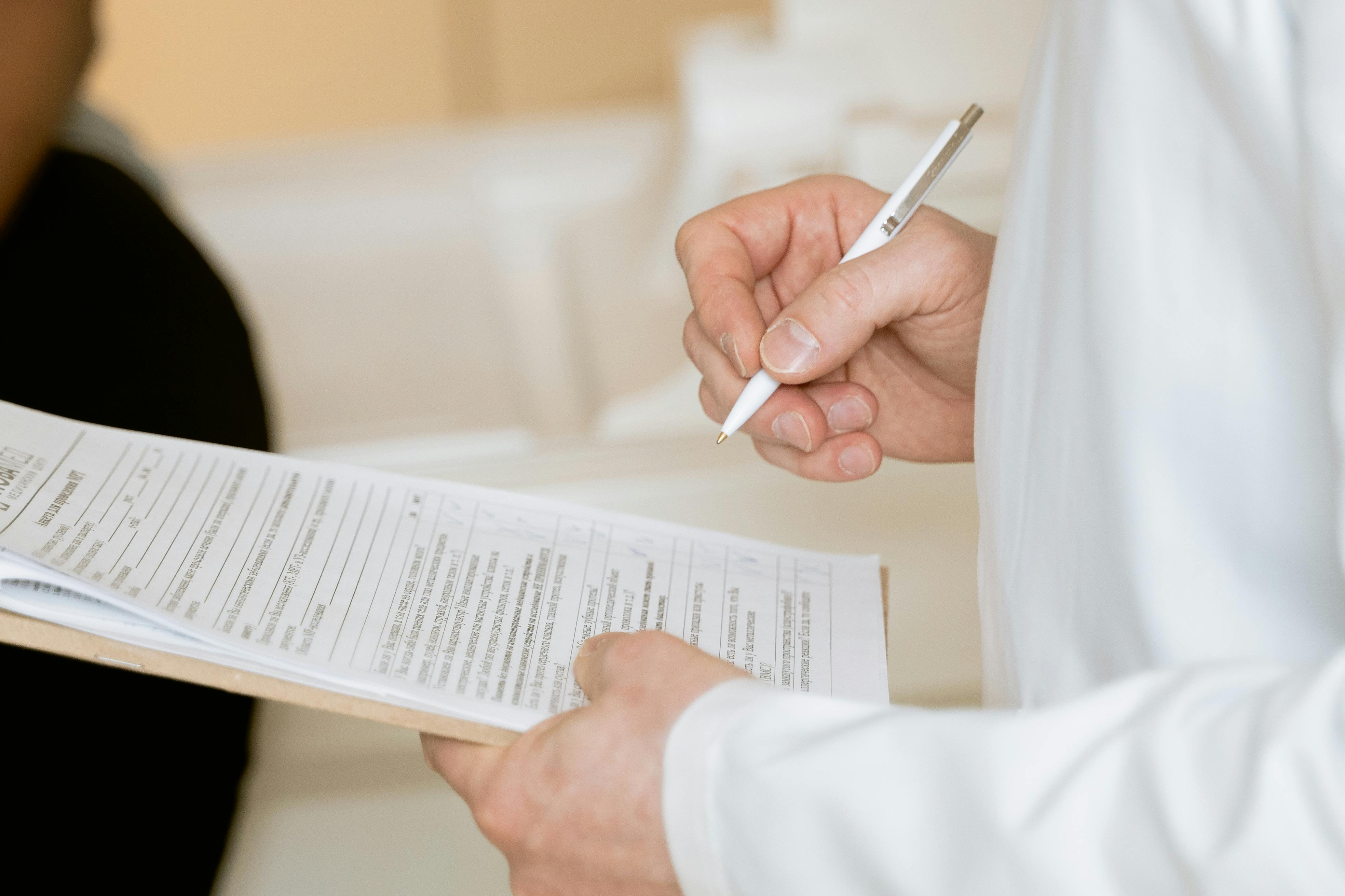 Un médecin tenant un presse-papier et un stylo | Source : Pexels