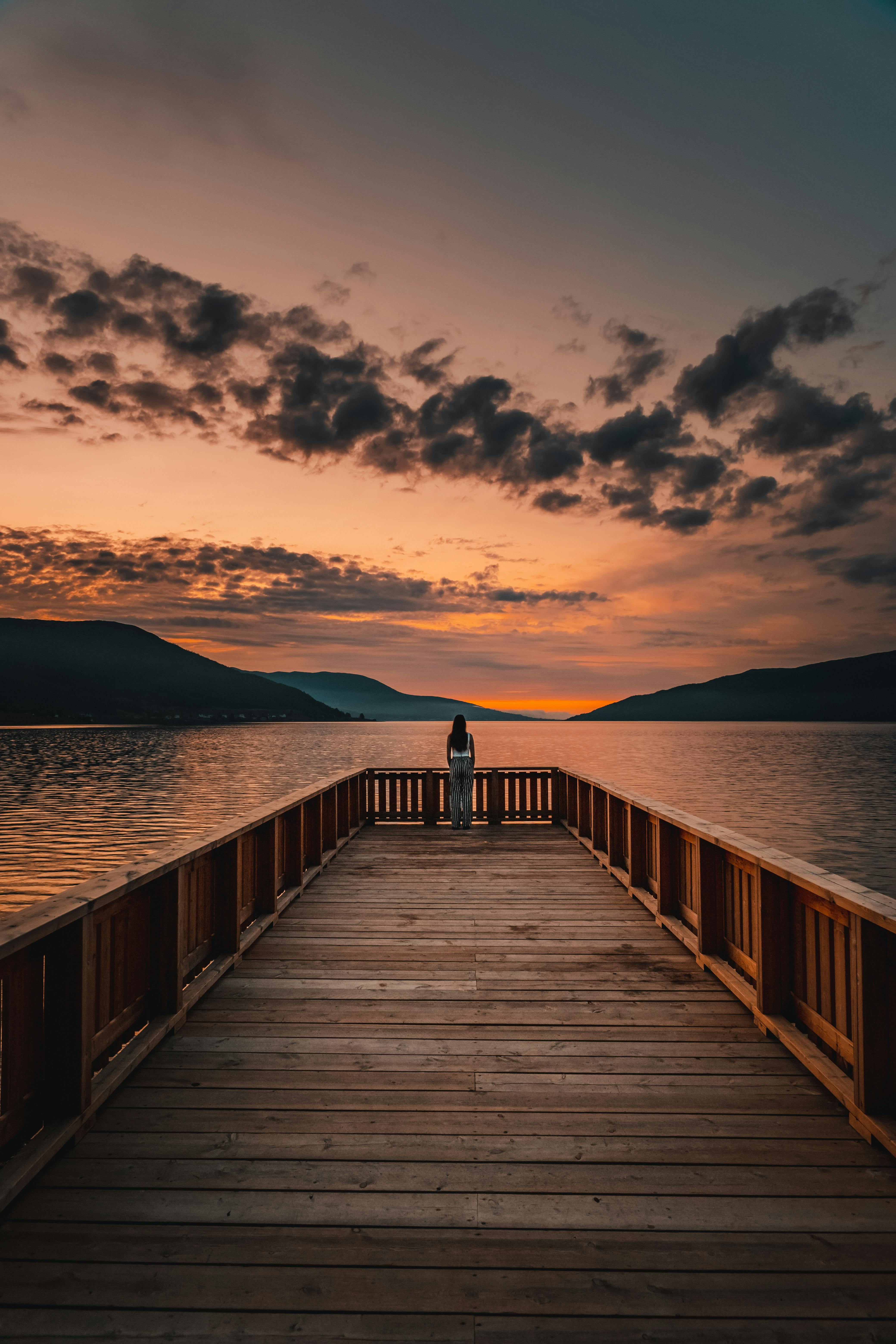 Une femme profitant de la vue d'un coucher de soleil | Source : Pexels