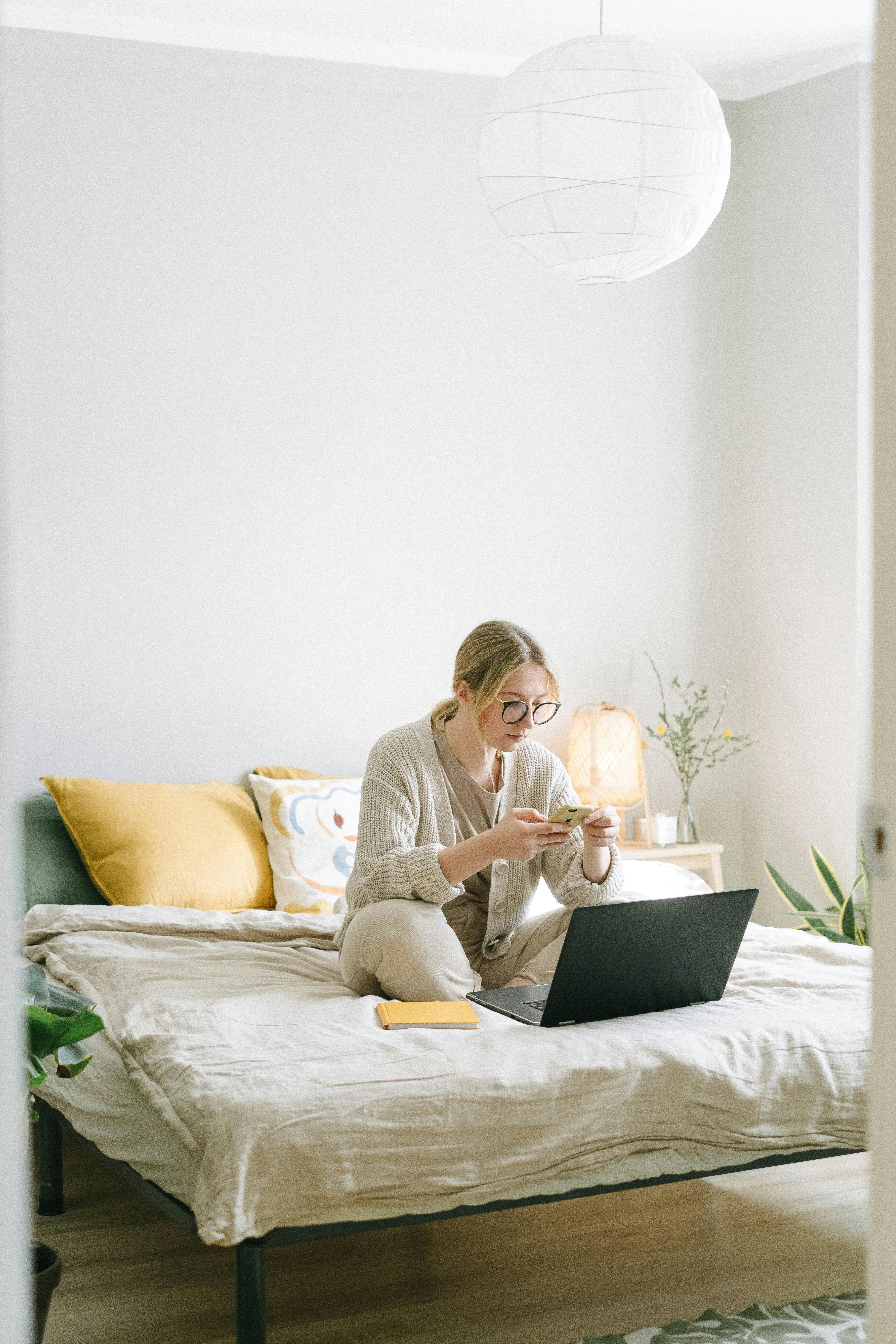 Une femme envoyant des textos sur son téléphone dans sa chambre | Source : Pexels