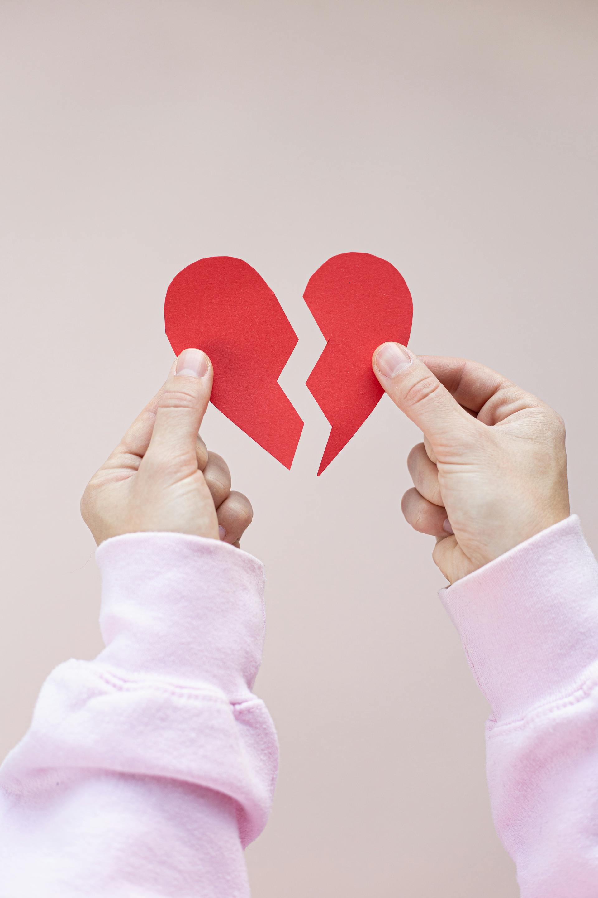 Une personne tenant un cœur en papier rouge brisé | Source : Pexels
