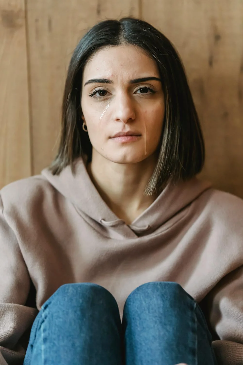 A crying woman wearing a hoodie | Source: Pexels