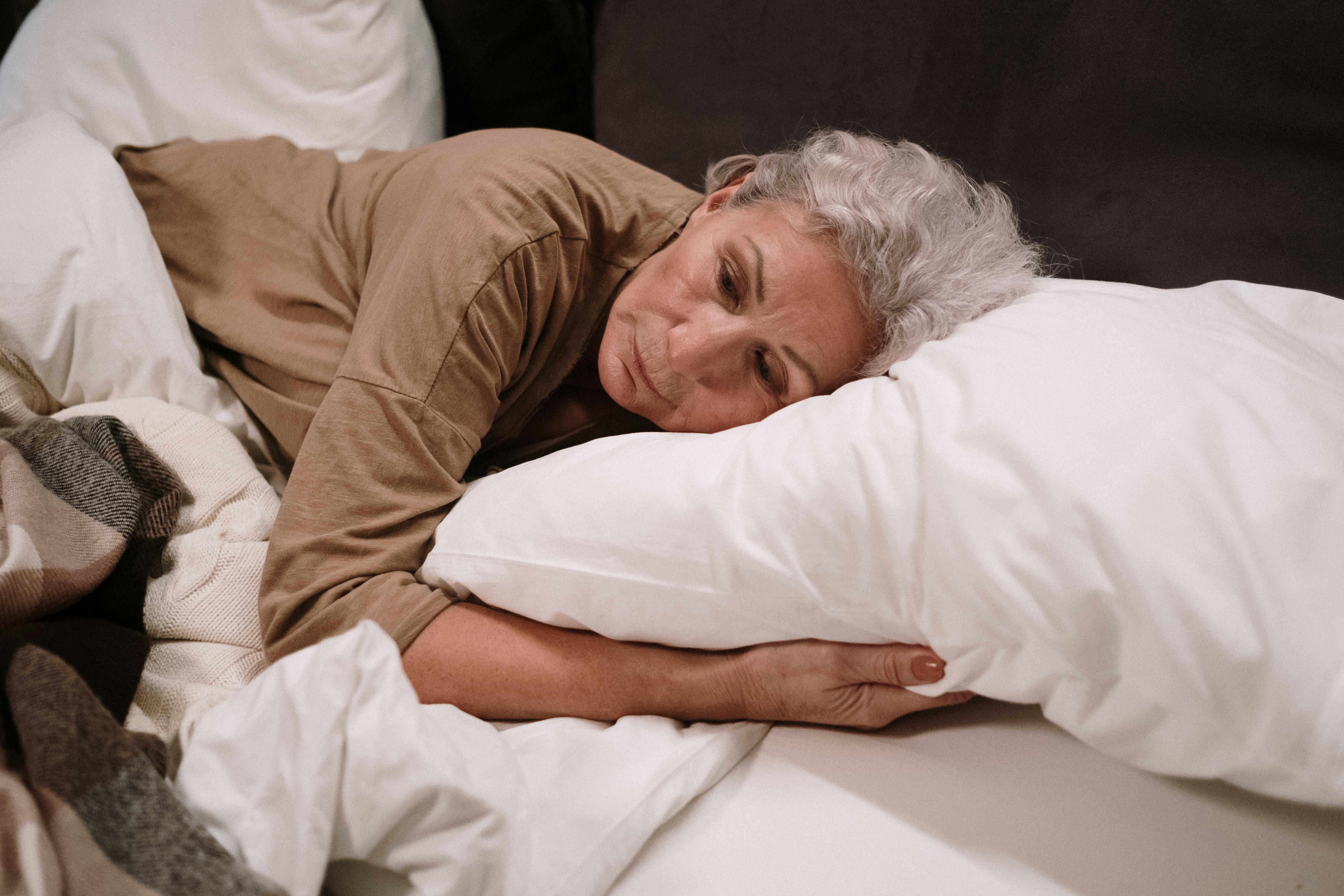Une femme âgée triste, allongée dans son lit, seule | Source : Pexels