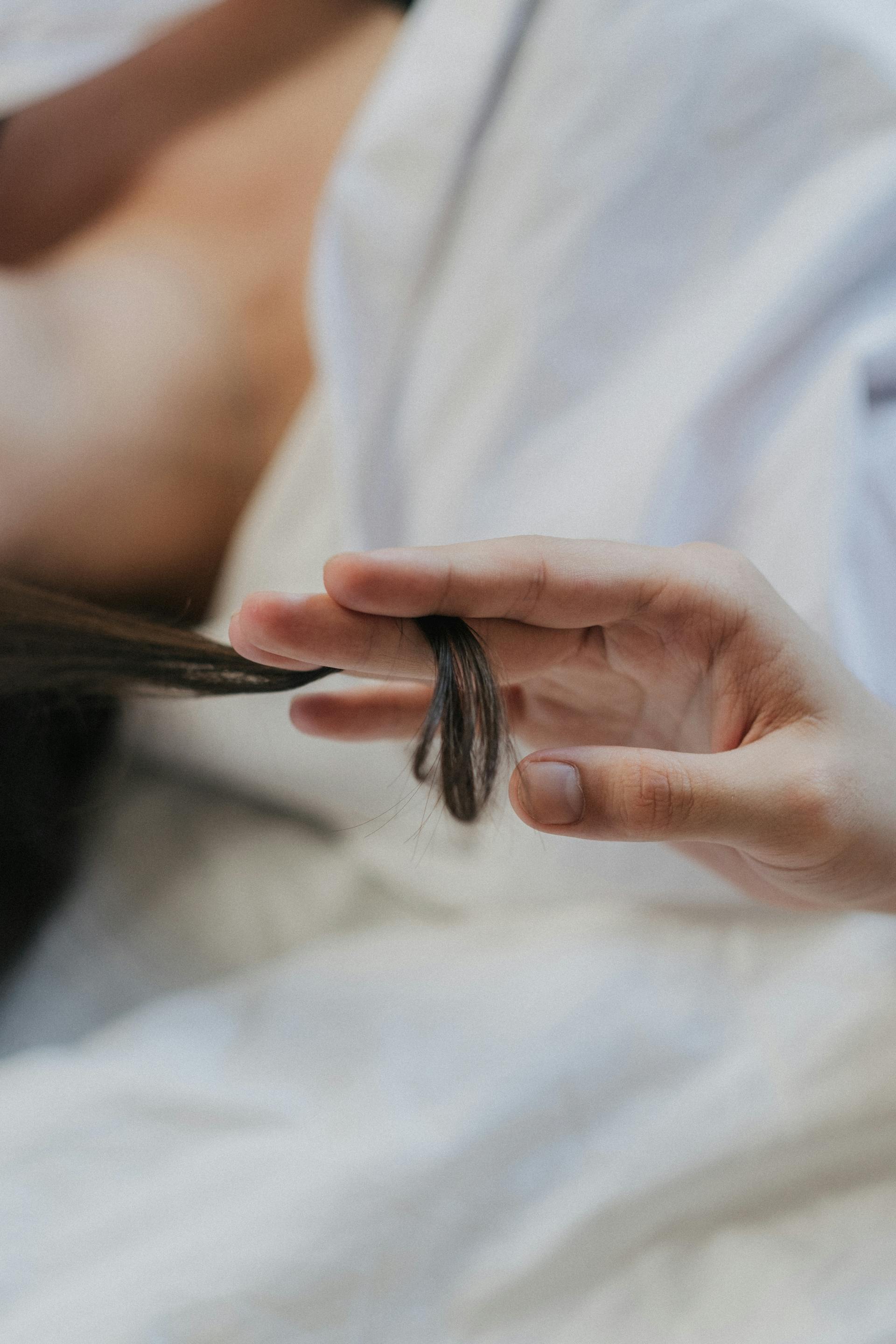Une personne qui tortille une mèche de cheveux | Source : Pexels
