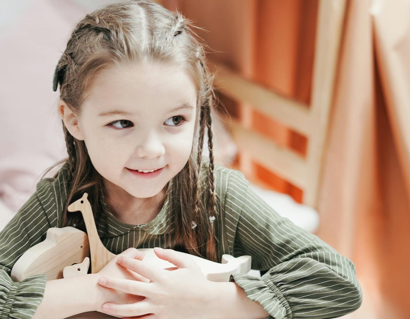 Une petite fille tenant ses jouets et souriant | Source : Pexels