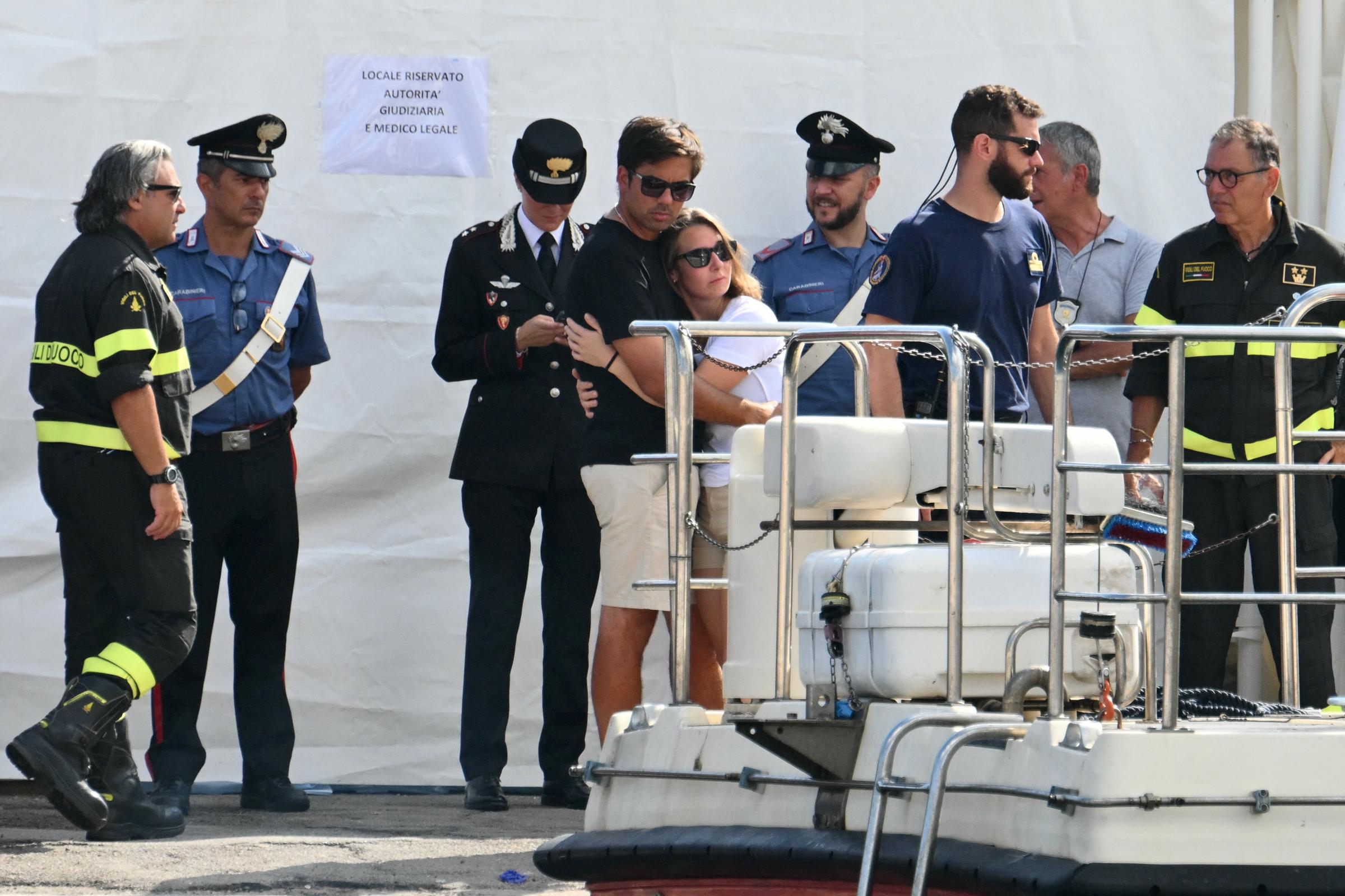 Des personnes s'étreignent en regardant une équipe de recherche et de sauvetage opérer sur la jetée de Porticello, en Italie, le 22 août 2024, trois jours après le naufrage du yacht de luxe Bayesian battant pavillon britannique. | Source : Getty Images