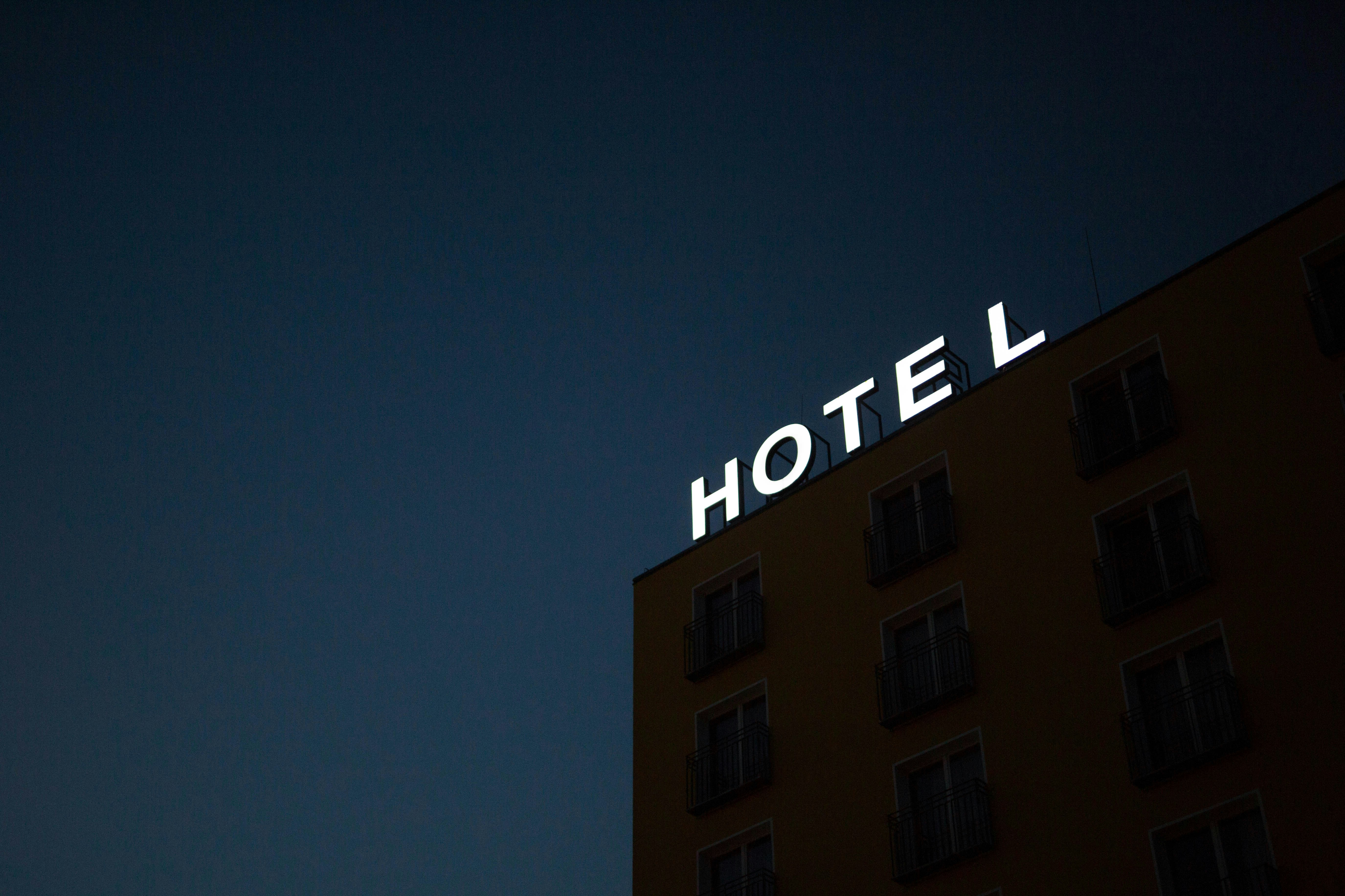 Une enseigne au néon indiquant "HOTEL" au sommet d'un bâtiment | Source : Unsplash