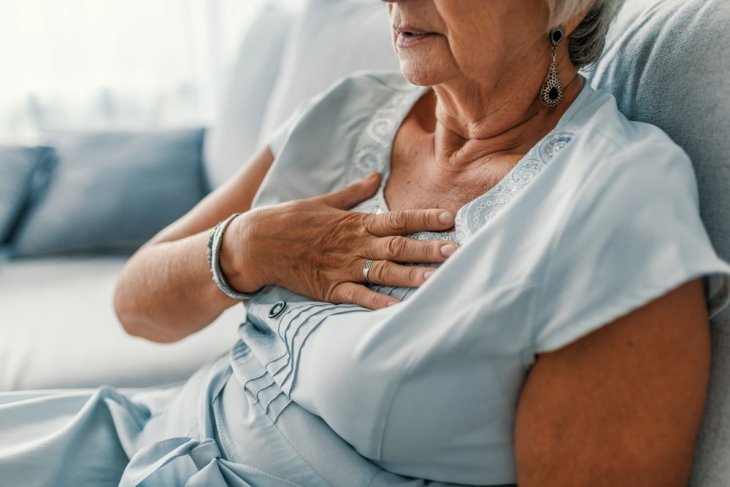 Une vieille femme tenant sa poitrine | Photo : Shutterstock