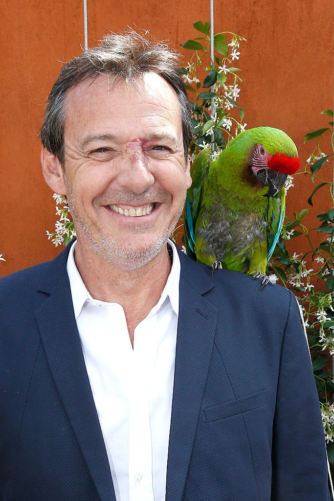 jean-Luc Reichmann pose avec un perroquet. | Photo : Getty Images