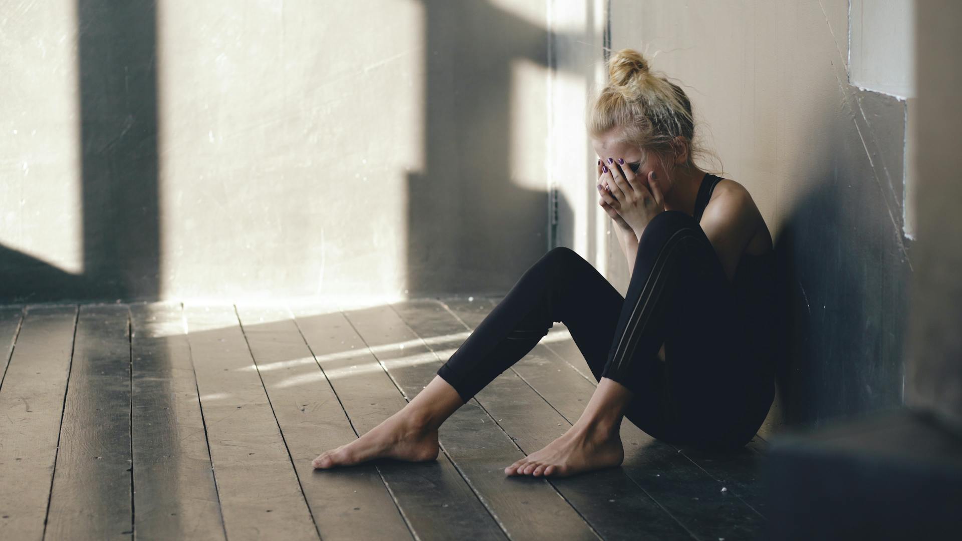 Une femme assise sur le sol, en train de pleurer | Source : Pexels