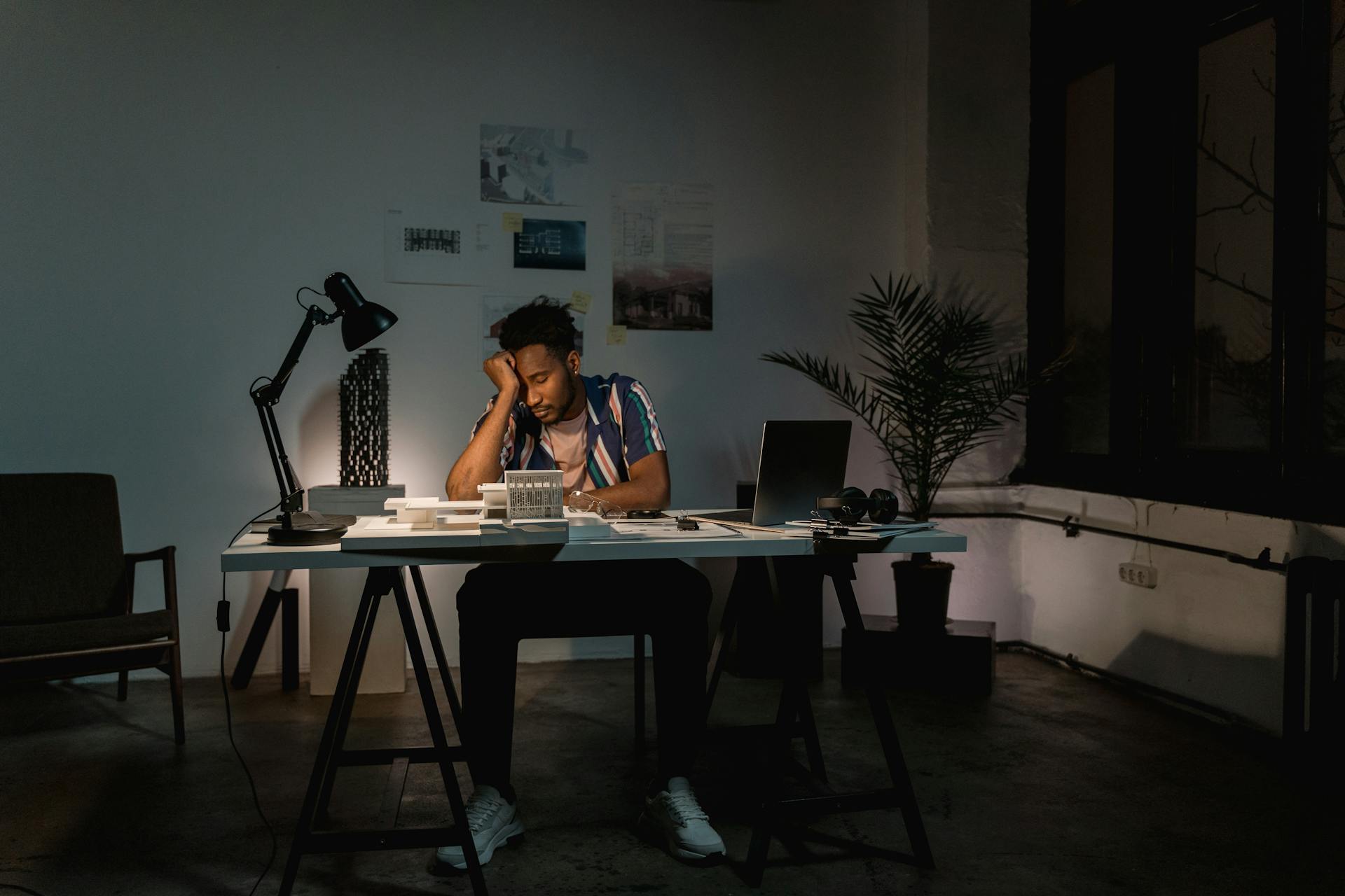 Un homme assis derrière sa table de travail se sentant épuisé | Source : Pexels