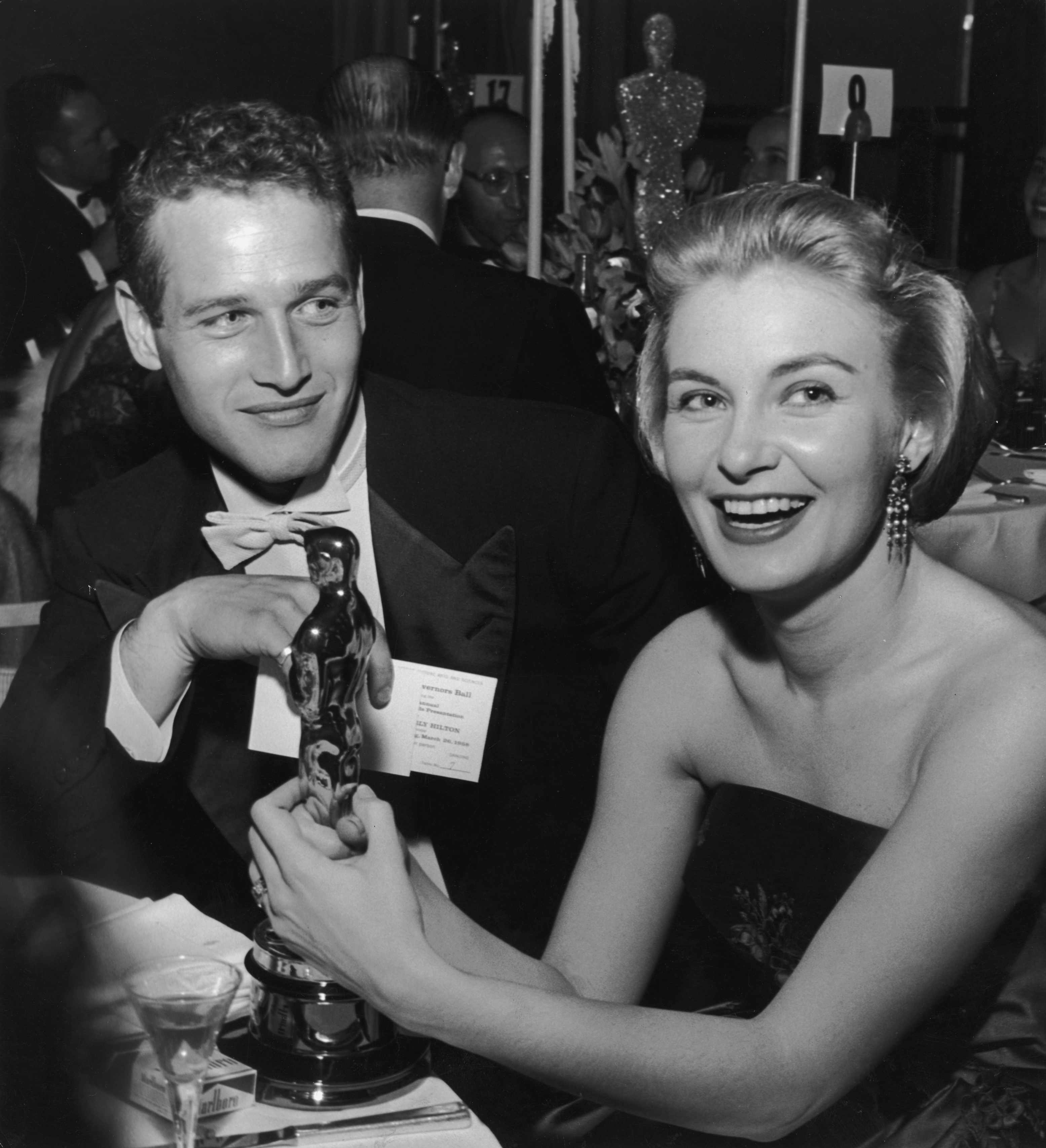 Joanne Woodward tient son Oscar pour "Les trois visages d'Eve" en 1958, assise à côté de son mari, Paul Newman, lors d'une soirée de remise des Oscars : Getty Images