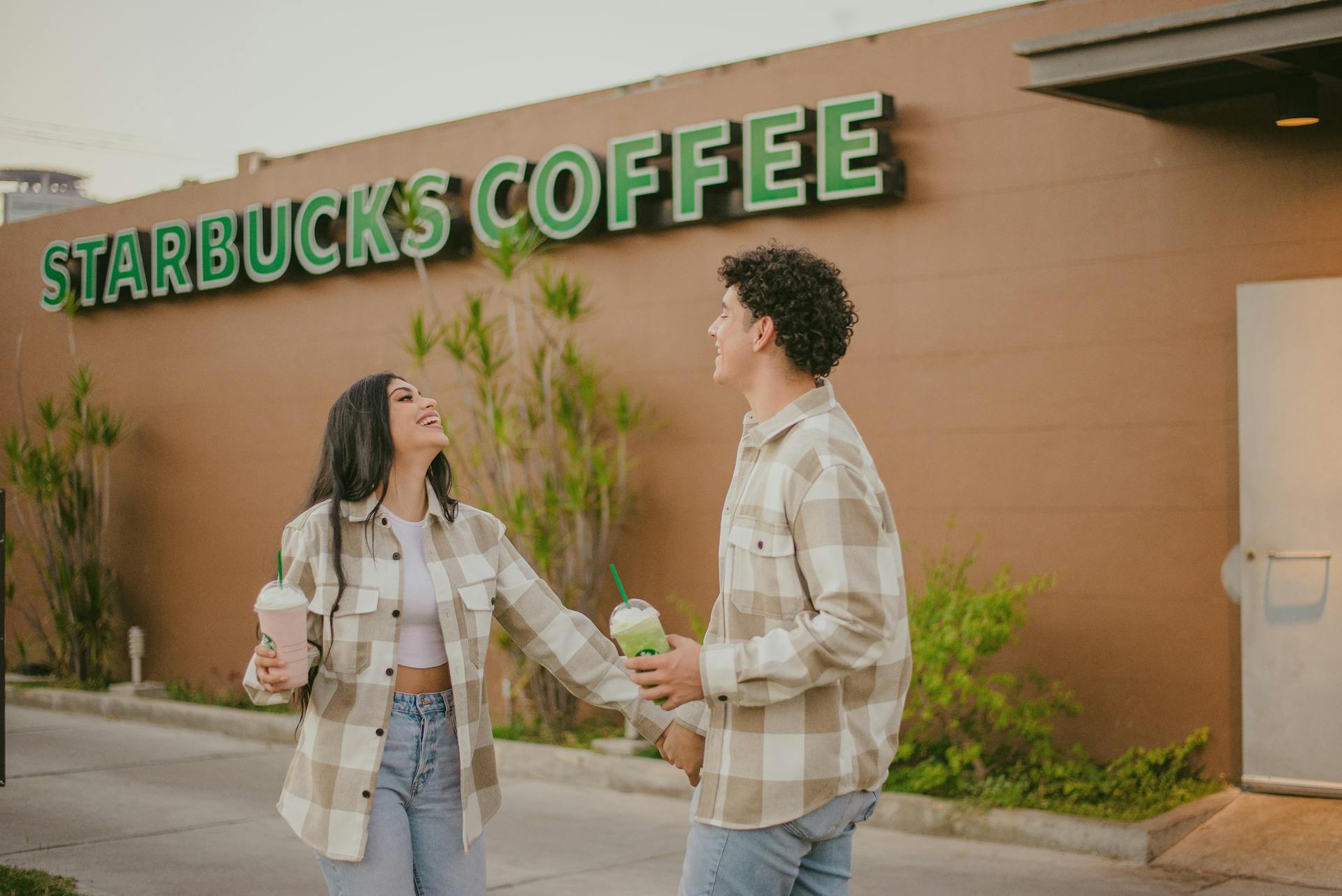 Un couple sortant d'un Starbucks | Source : Pexels