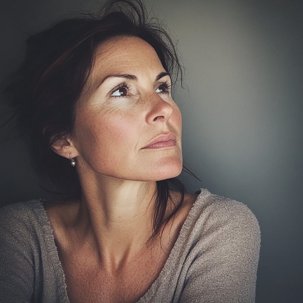 Une femme pensive âgée d'une quarantaine d'années | Source : Midjourney