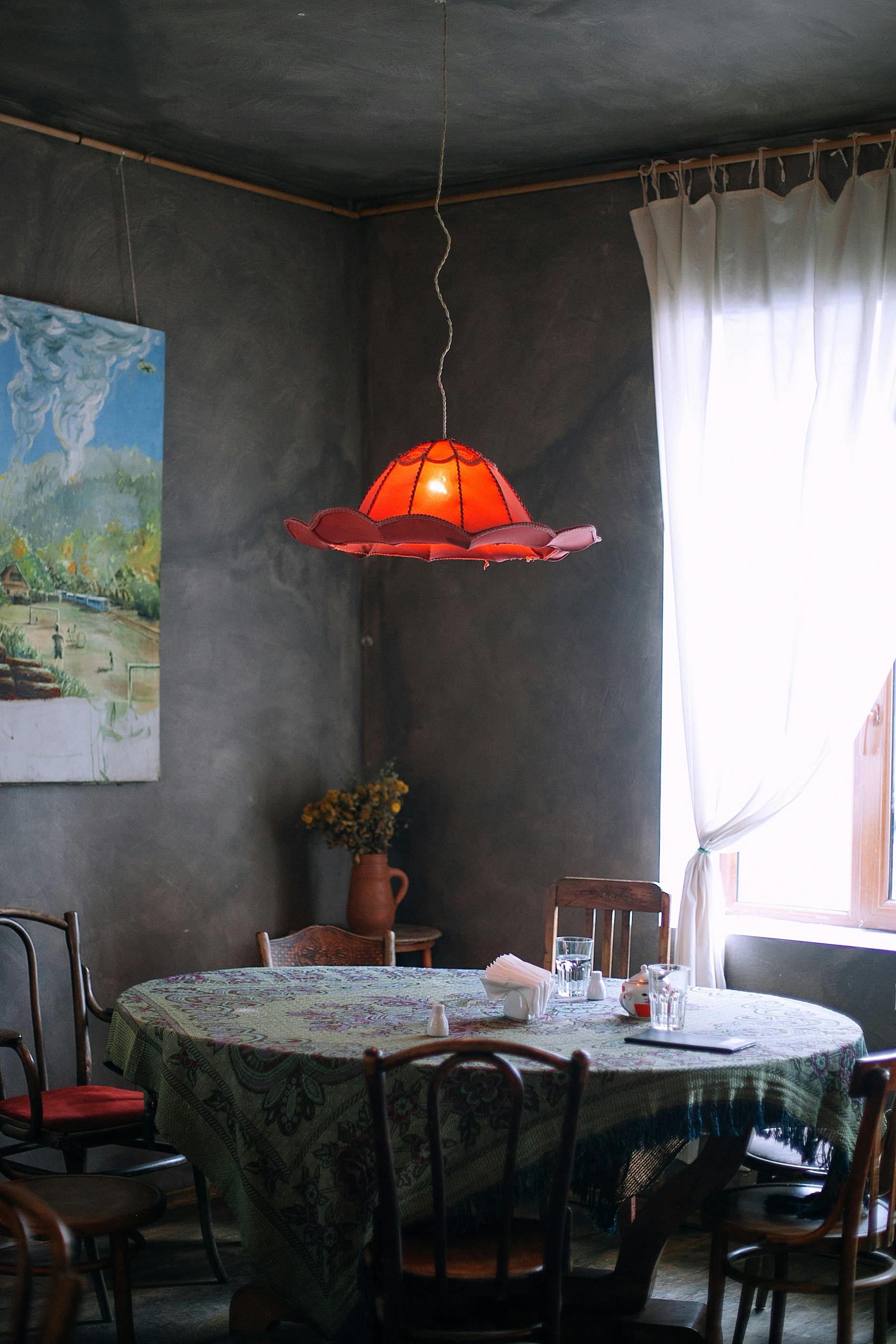 Une pièce avec des murs gris et une table ronde avec des chaises | Source : Pexels