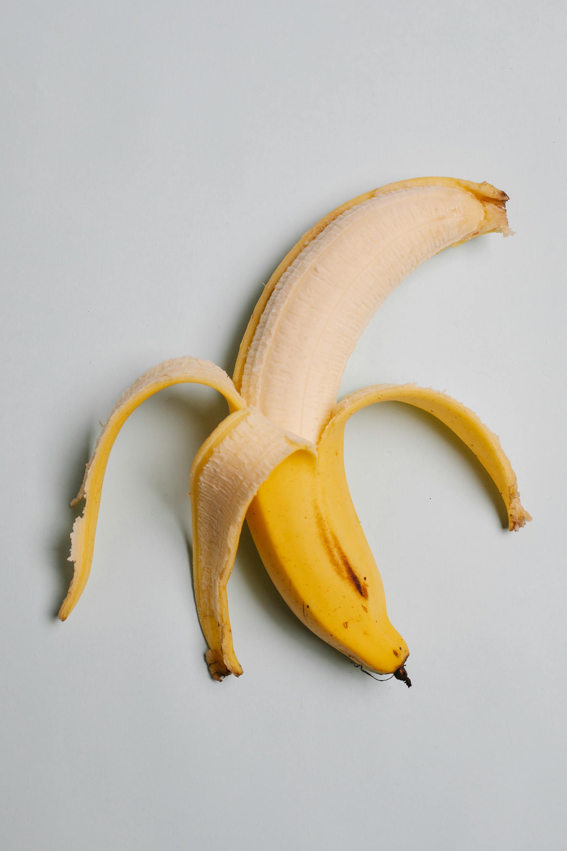 Une banane partiellement pelée | Source : Pexels