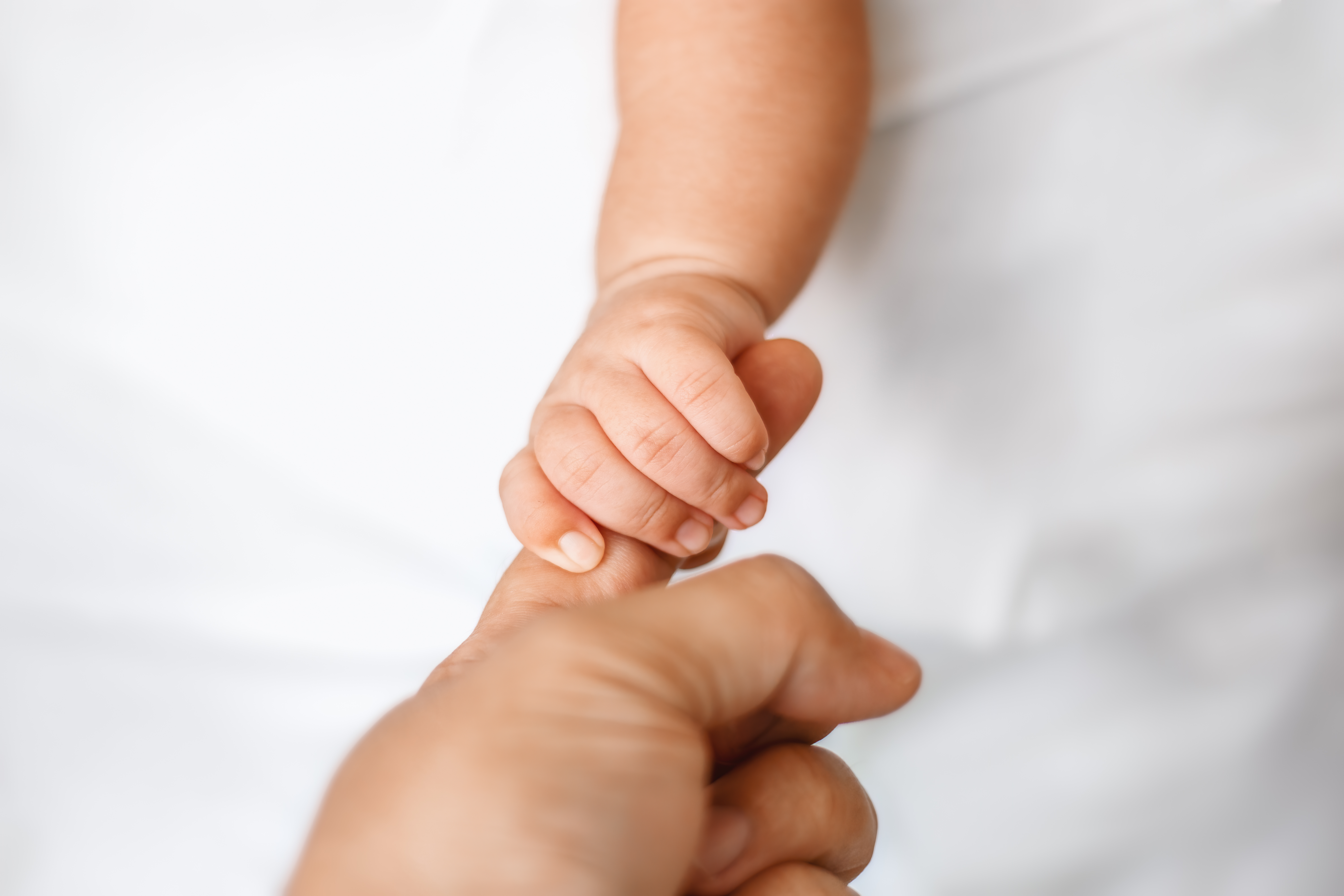 Un nouveau-né tenant un doigt d'adulte | Source : Getty Images