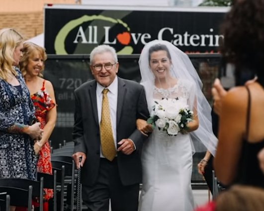 Jim Stamp marchant sa fille Gina dans l’allée à son mariage. | YouTube/GMA