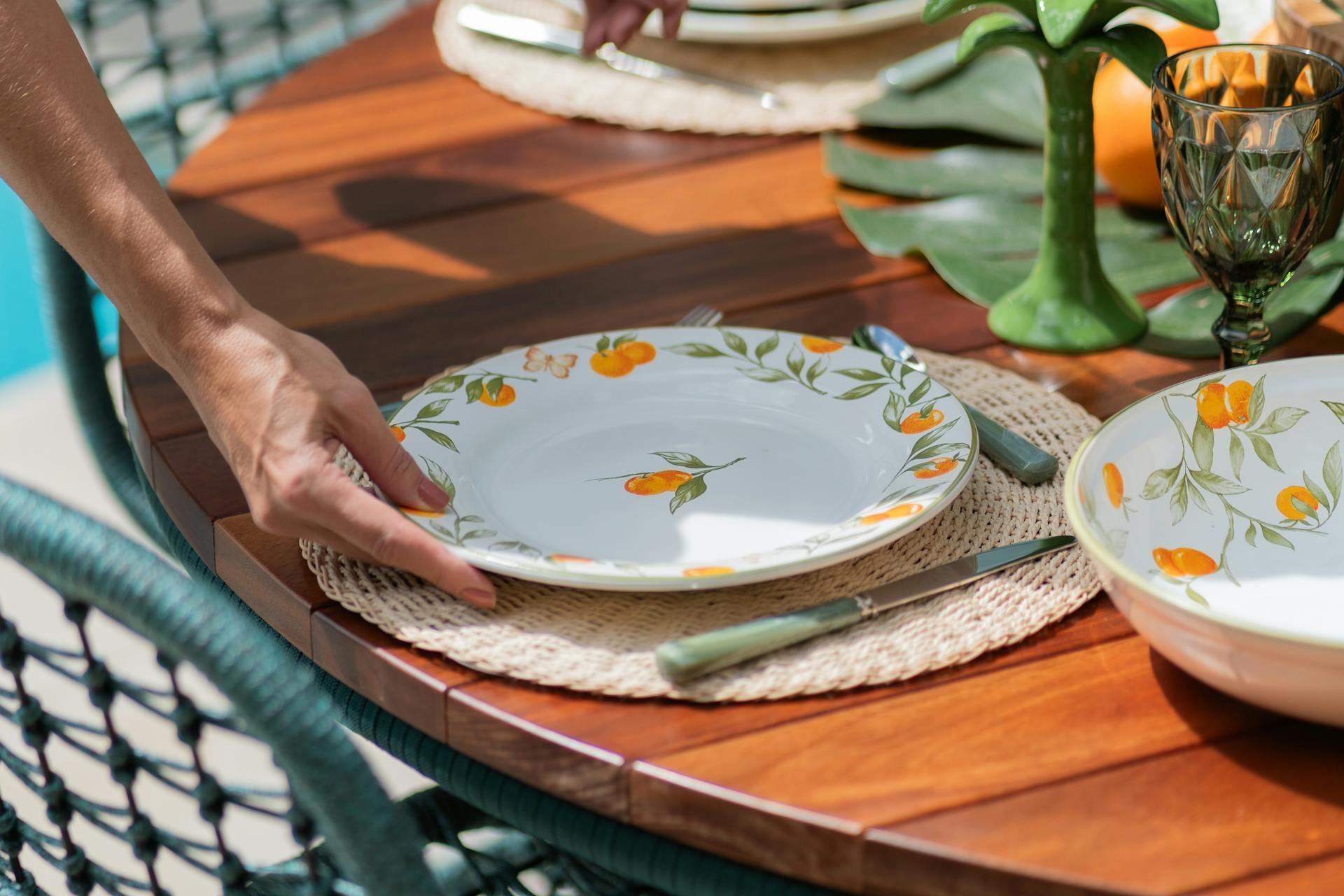 Une femme pose une assiette sur une table | Source : Pexels