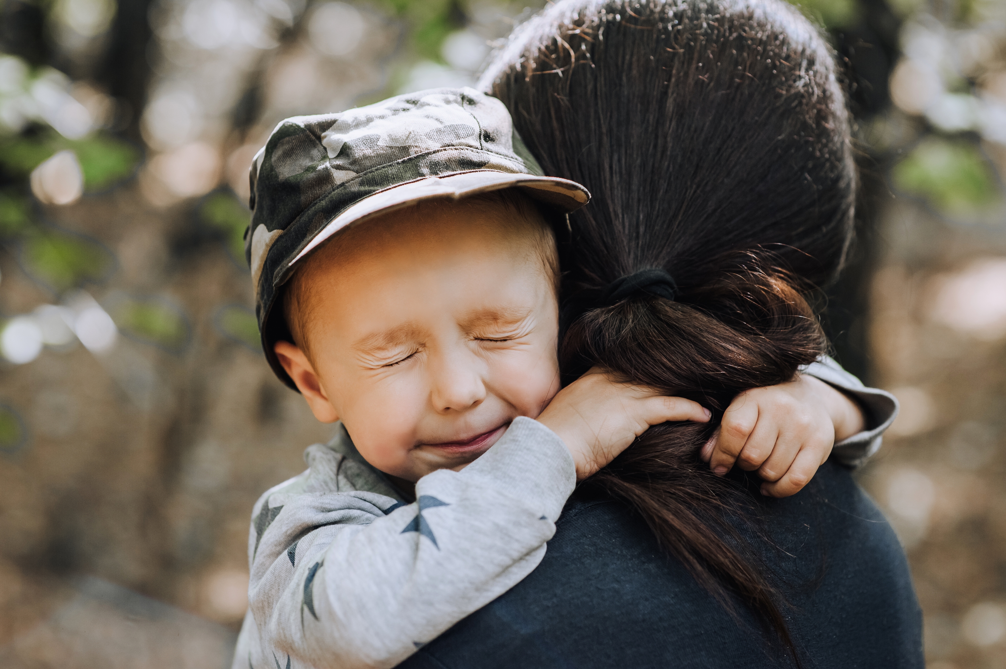 Un petit garçon qui serre une femme dans ses bras, les yeux fermés | Source : Shutterstock