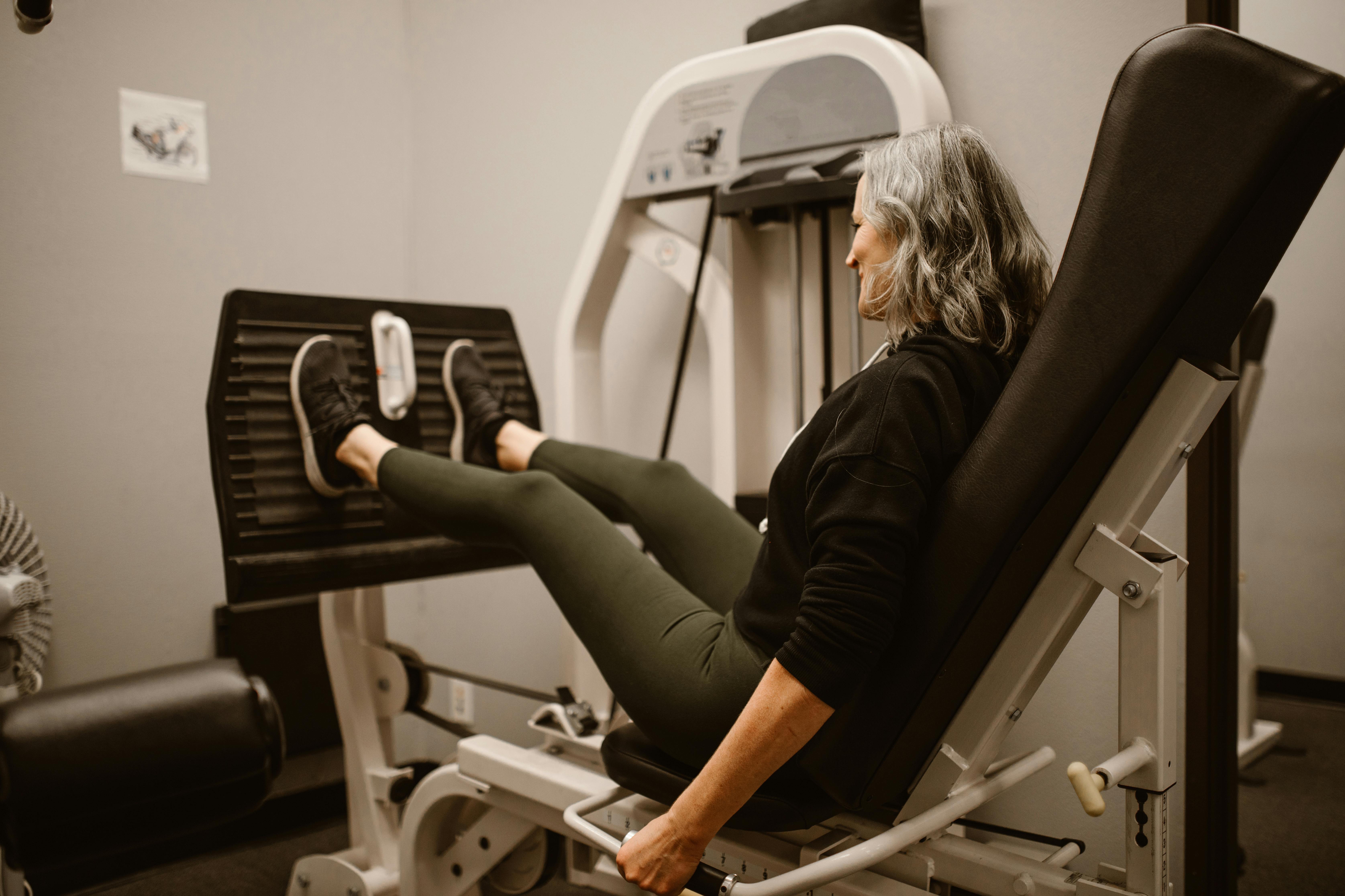 Femme utilisant une machine à presser les jambes dans une salle de sport | Source : Pexels