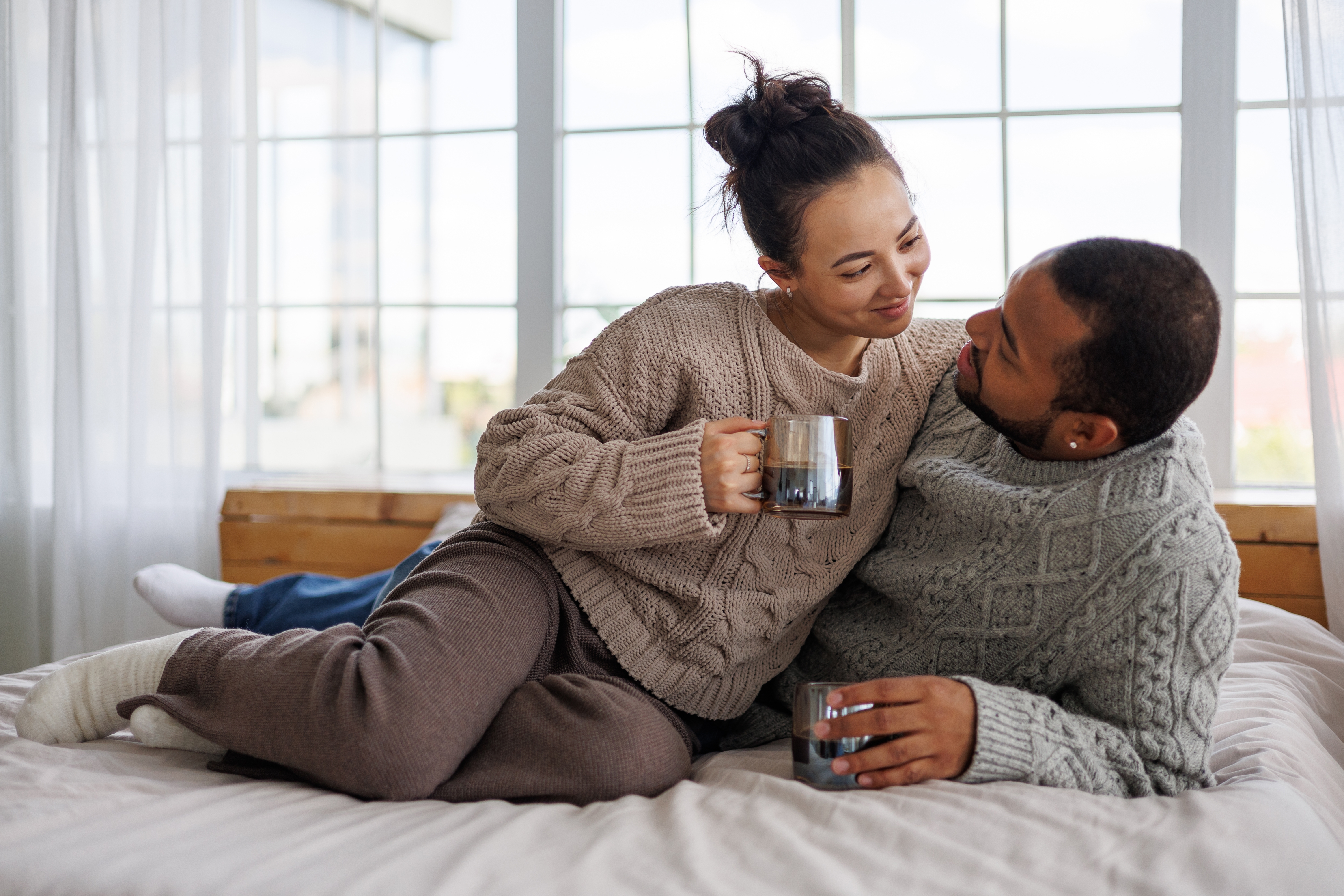 Un couple heureux qui a l'air bien installé sur un lit | Source : Shutterstock