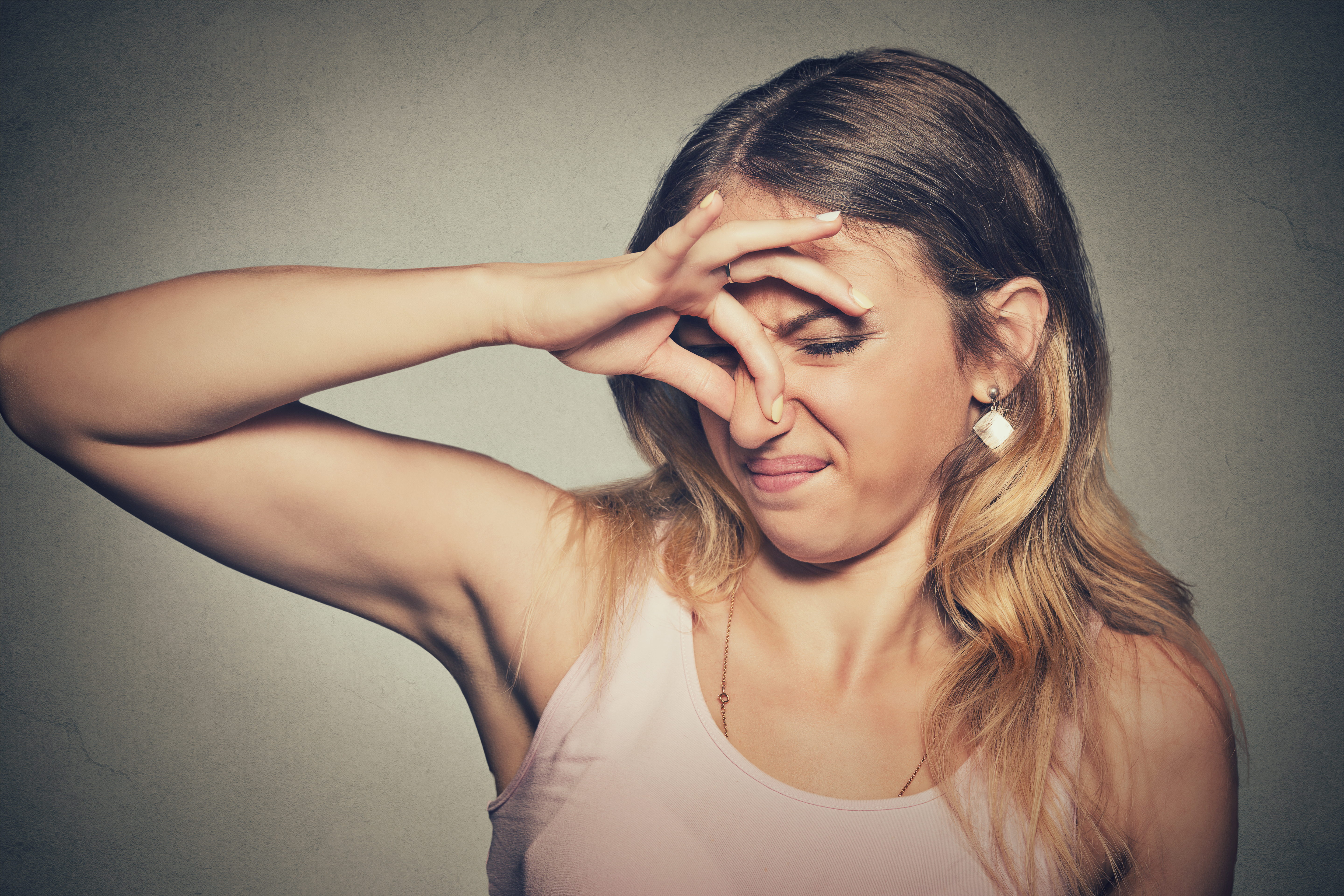 Mujer se tapa la nariz con los dedos | Fuente: Shutterstock