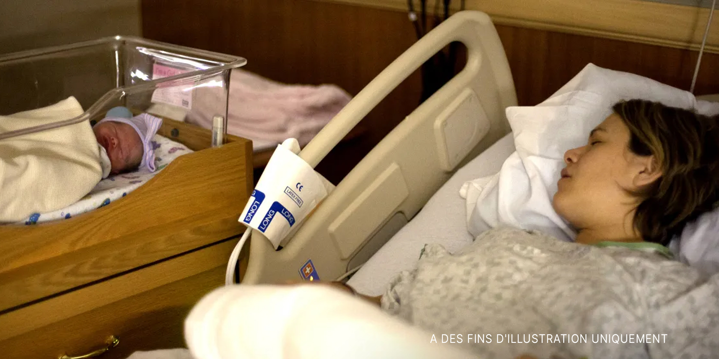 Une femme dormant dans un lit d'hôpital à côté de son nouveau-né | Source : Flickr.com/Lars Plougmann/CC BY-SA 2.0