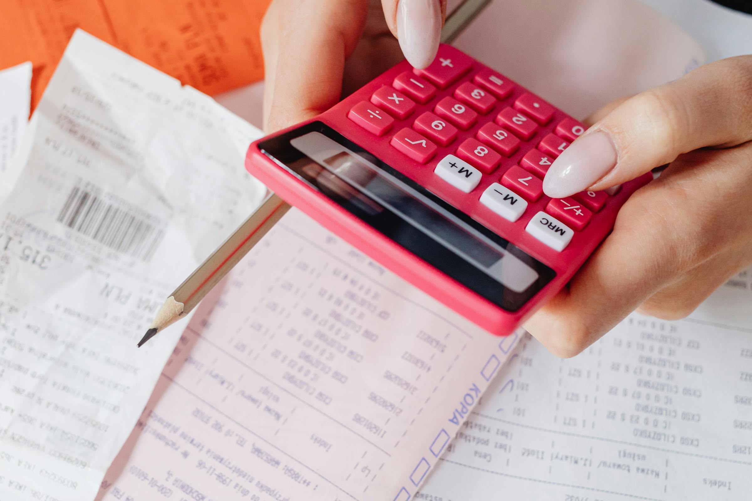 Une femme utilisant une calculatrice tout en s'occupant de factures | Source : Pexels