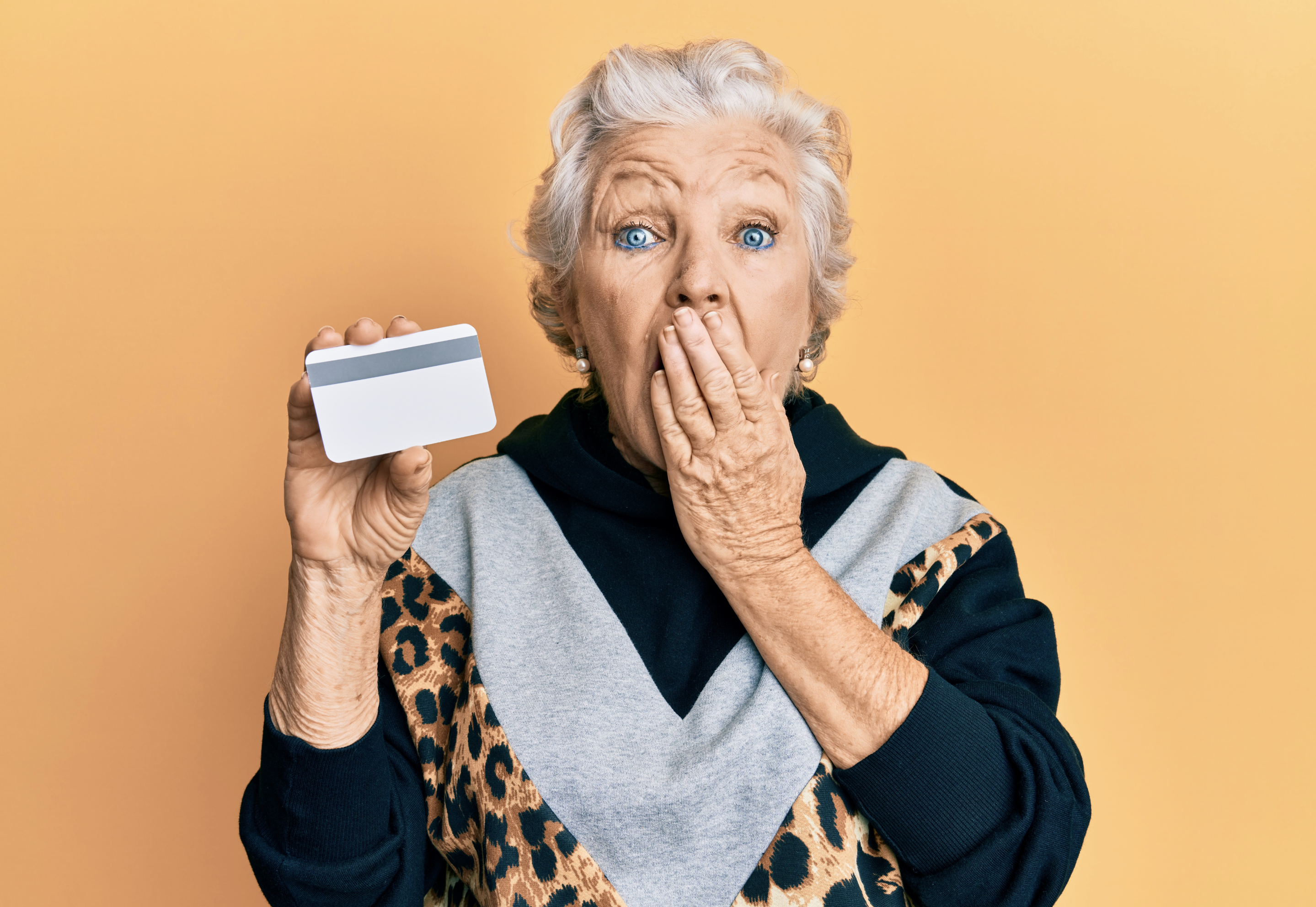 Une femme âgée tenant une carte de crédit | Source : Shutterstock