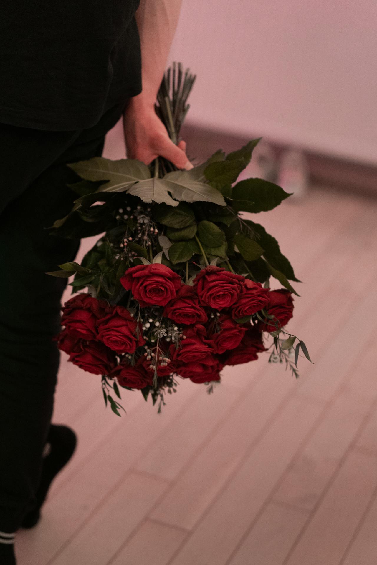 Un homme tenant un bouquet de roses rouges | Source : Pexels