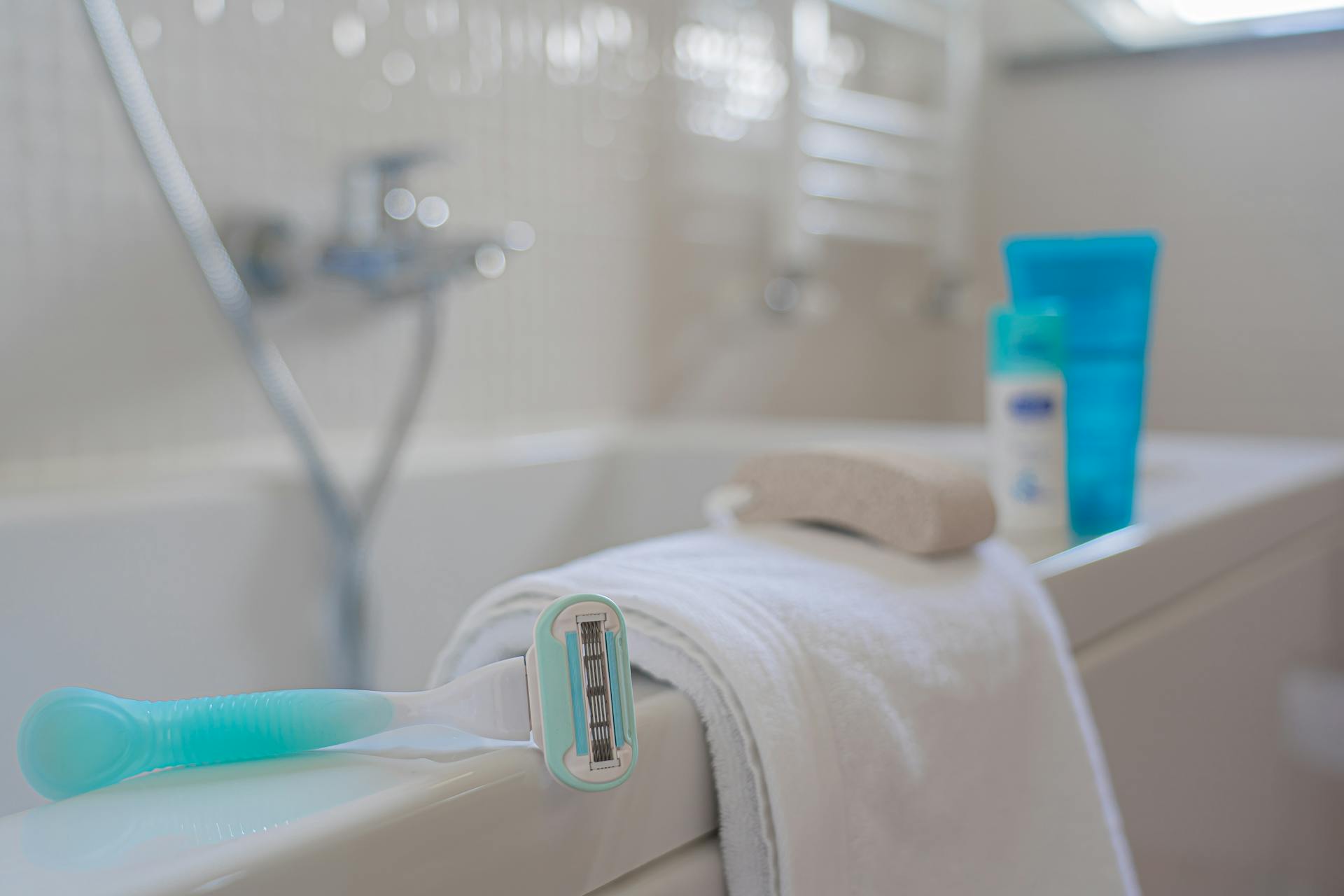 Un rasoir et une serviette dans une salle de bain | Source : Pexels