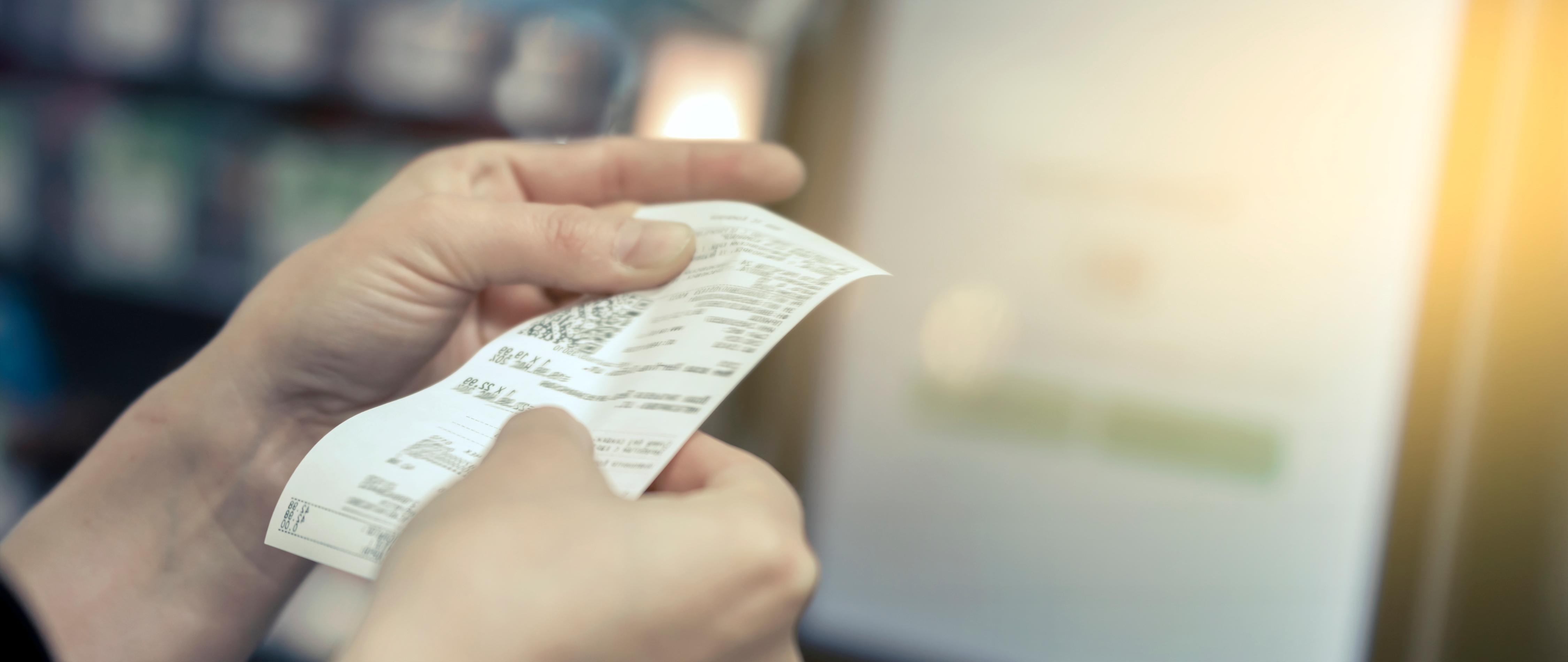 Une femme tenant un ticket de caisse d'épicerie | Source : Shutterstock