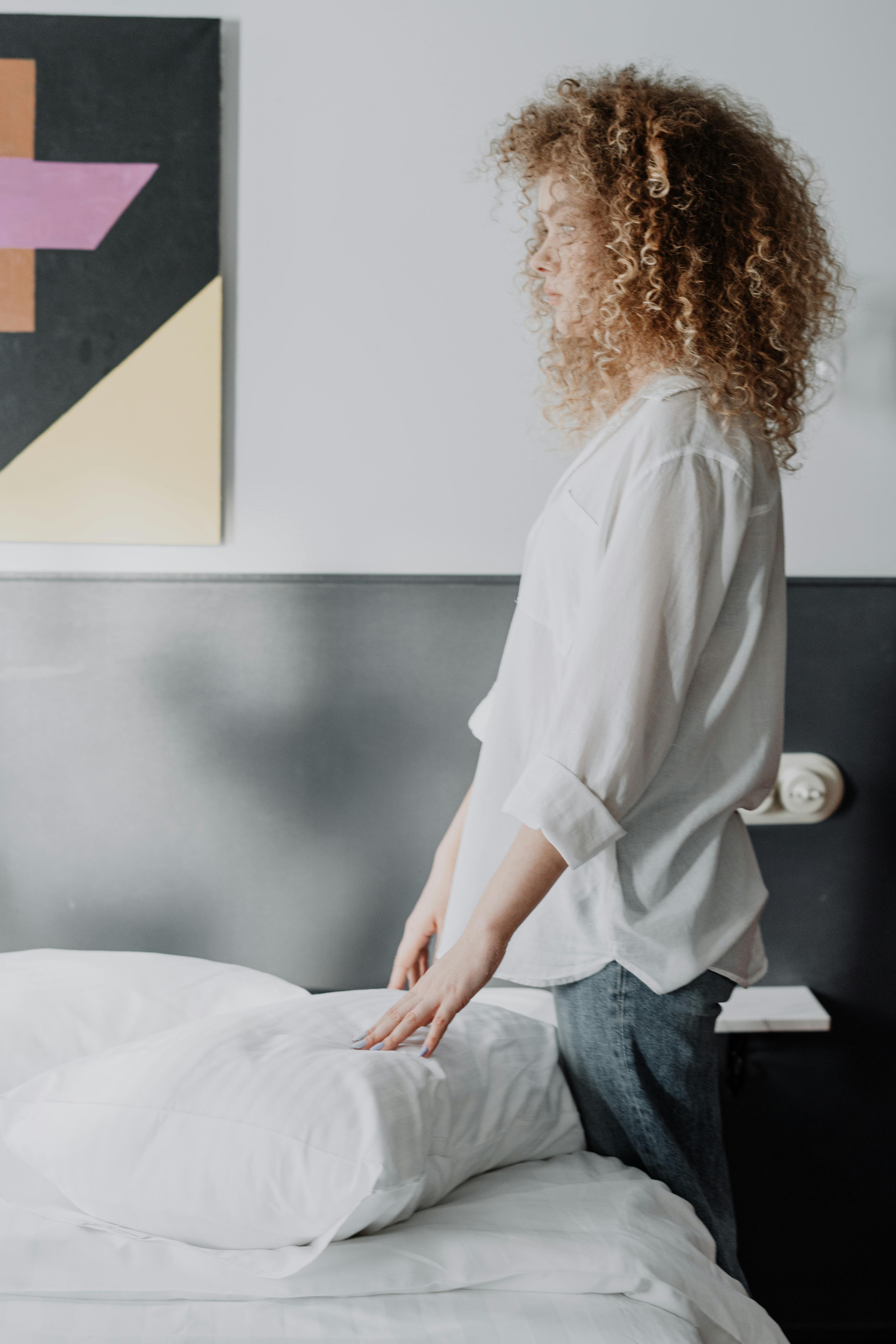 Une femme debout près d'un lit | Source : Pexels