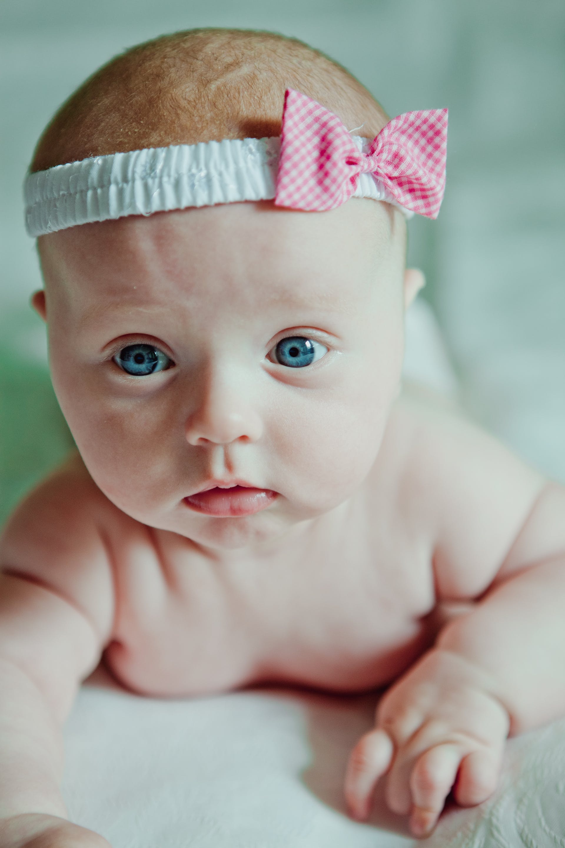 Un gros plan d'un nouveau-né aux yeux bleus avec un bandeau | Source : Pexels