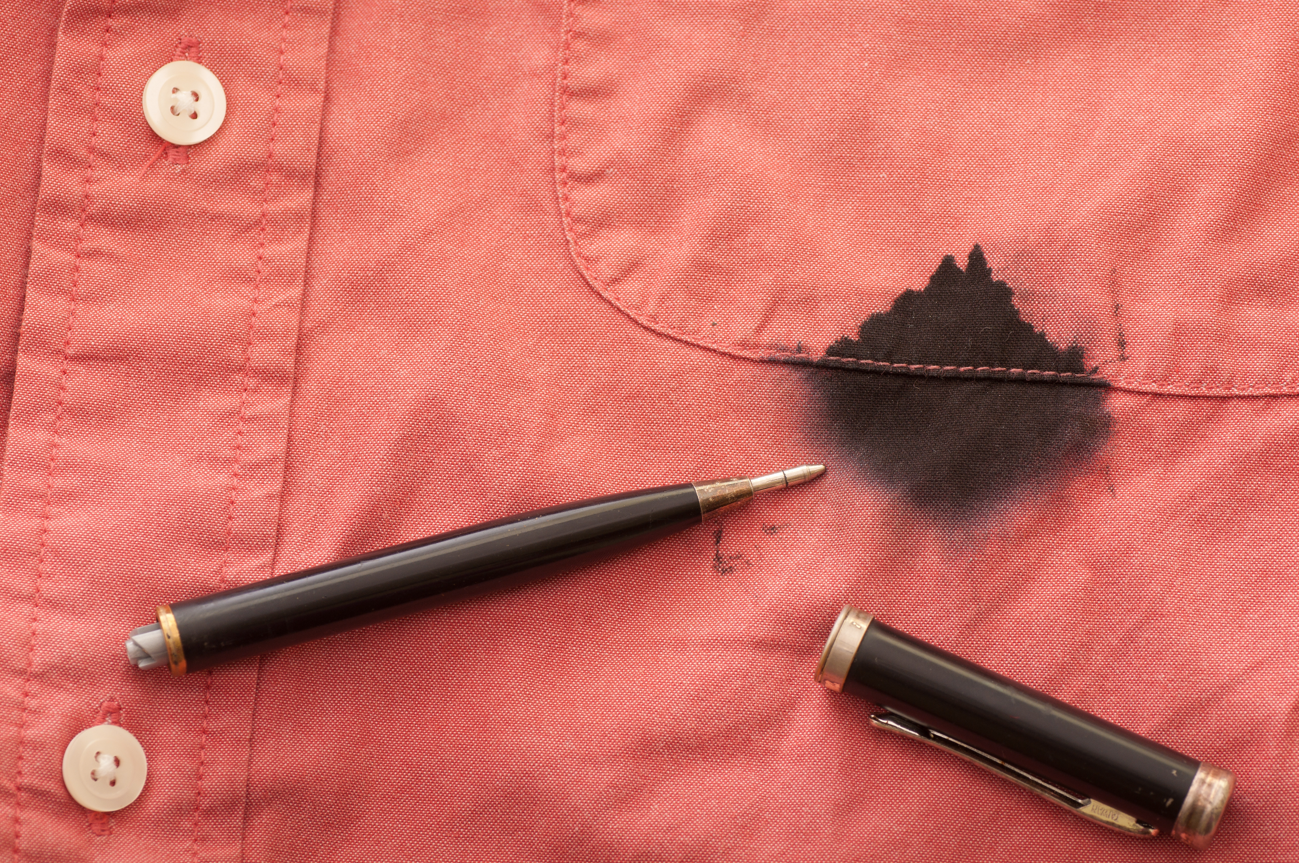 Une tache de stylo noir et d'encre sur une chemise couleur saumon | Source : Shutterstock
