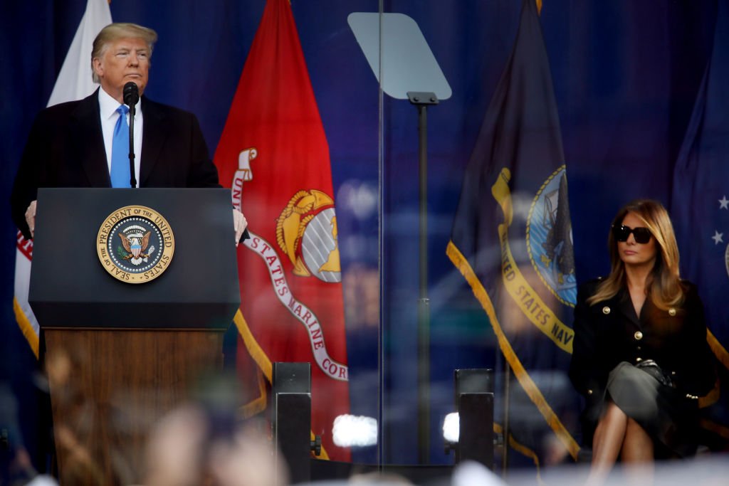 Le président Donald Trump prend la parole lors de la cérémonie d'ouverture du défilé de la Journée des anciens combattants alors que la première dame Melania Trump écoute | Photo: Getty Images