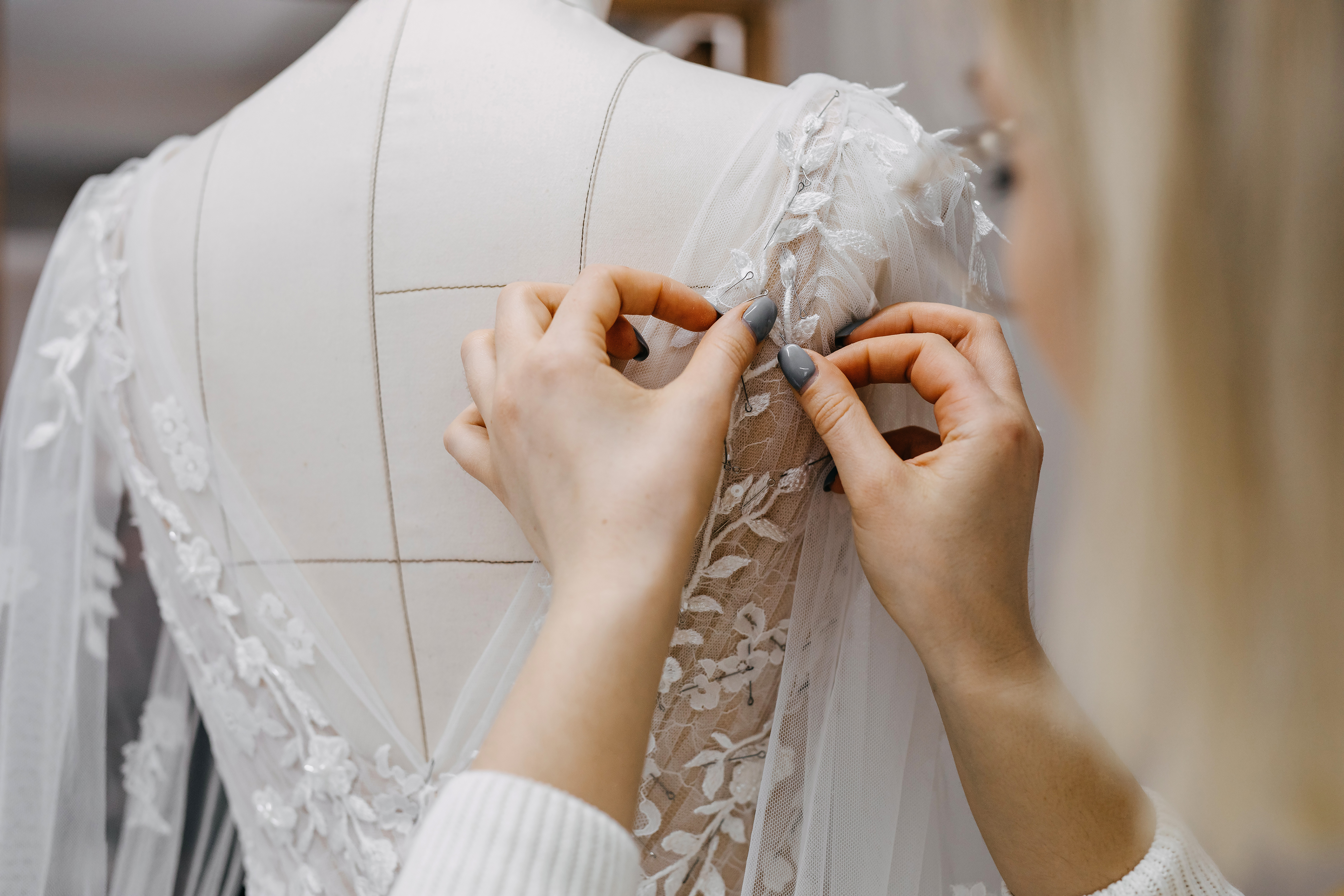 Une femme en train de coudre une robe de mariée | Source : Shutterstock