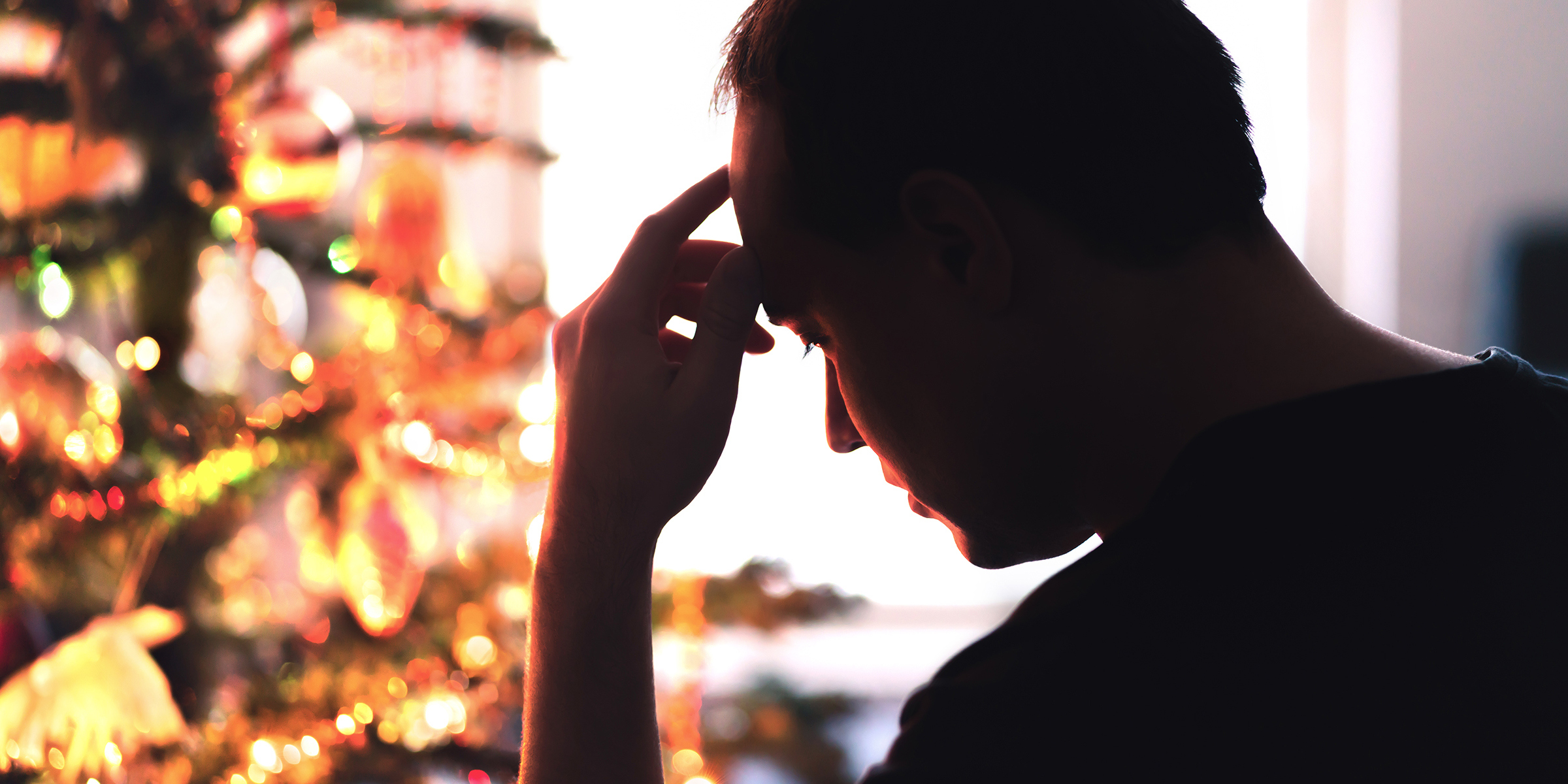 Homme regardant un sapin de Noël | Source : Getty Images