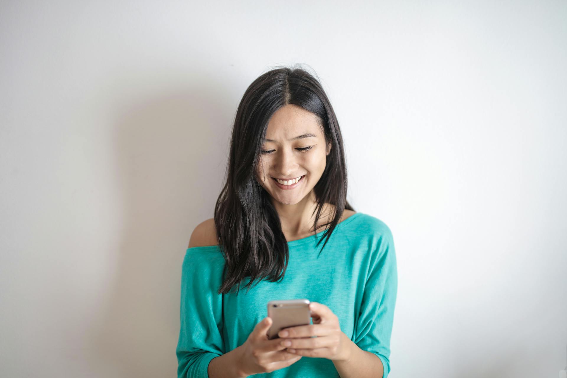 Une femme qui sourit à son téléphone | Source : Pexels