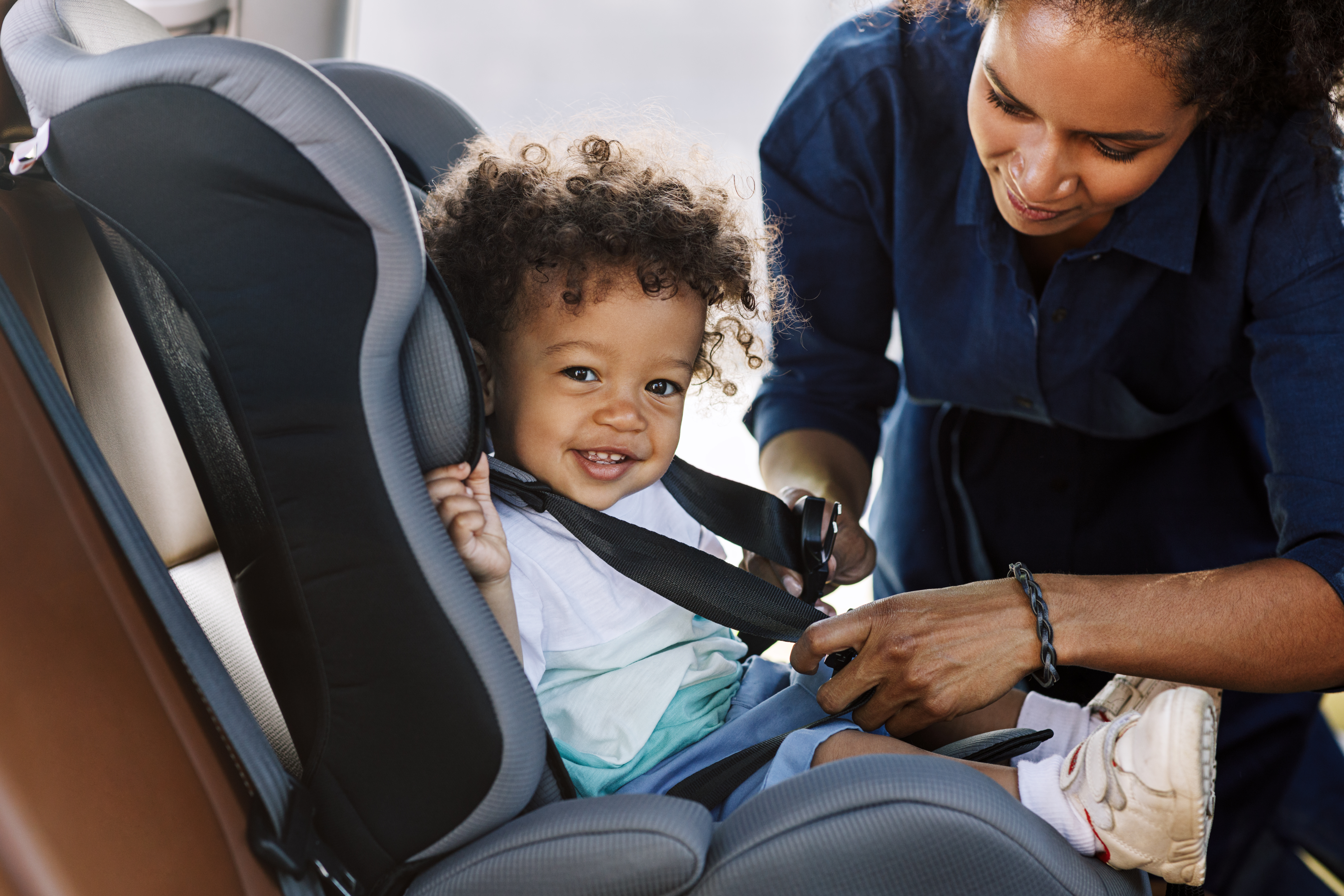 Une mère attache son enfant à un siège auto | Source : Shutterstock