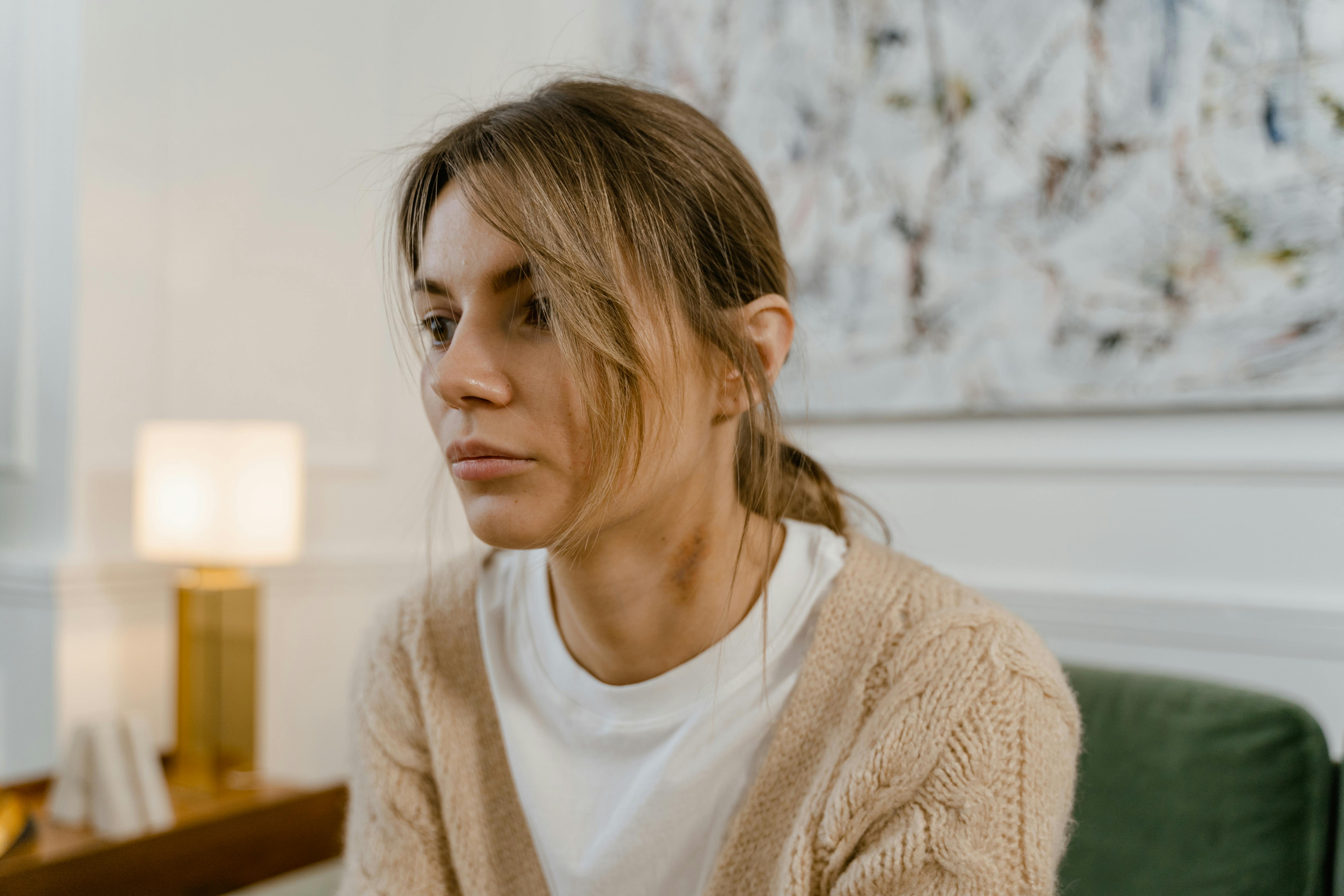 Une femme sérieuse assise sur un canapé | Source : Pexels