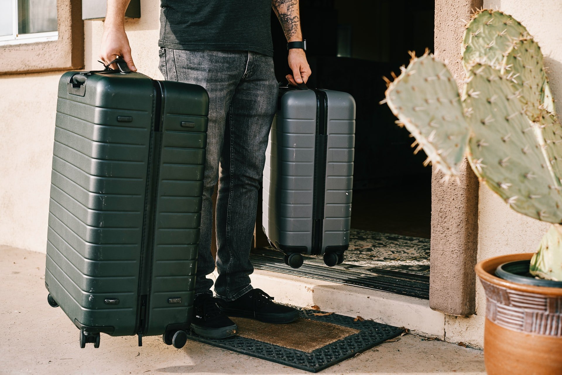 Un homme tenant deux valises | Source : Unsplash
