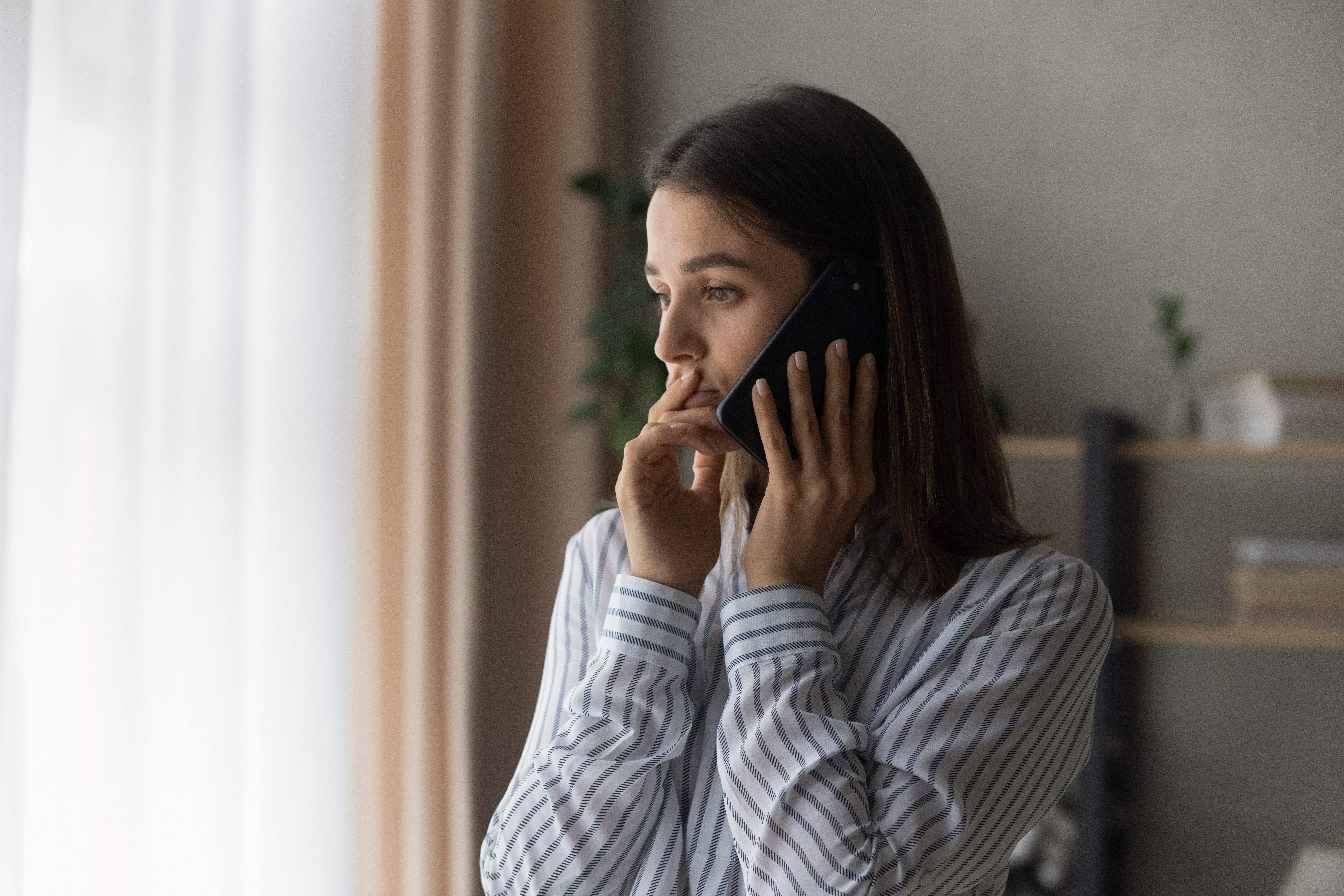 Une jeune fille au téléphone, l'air inquiet | Source : Shutterstock